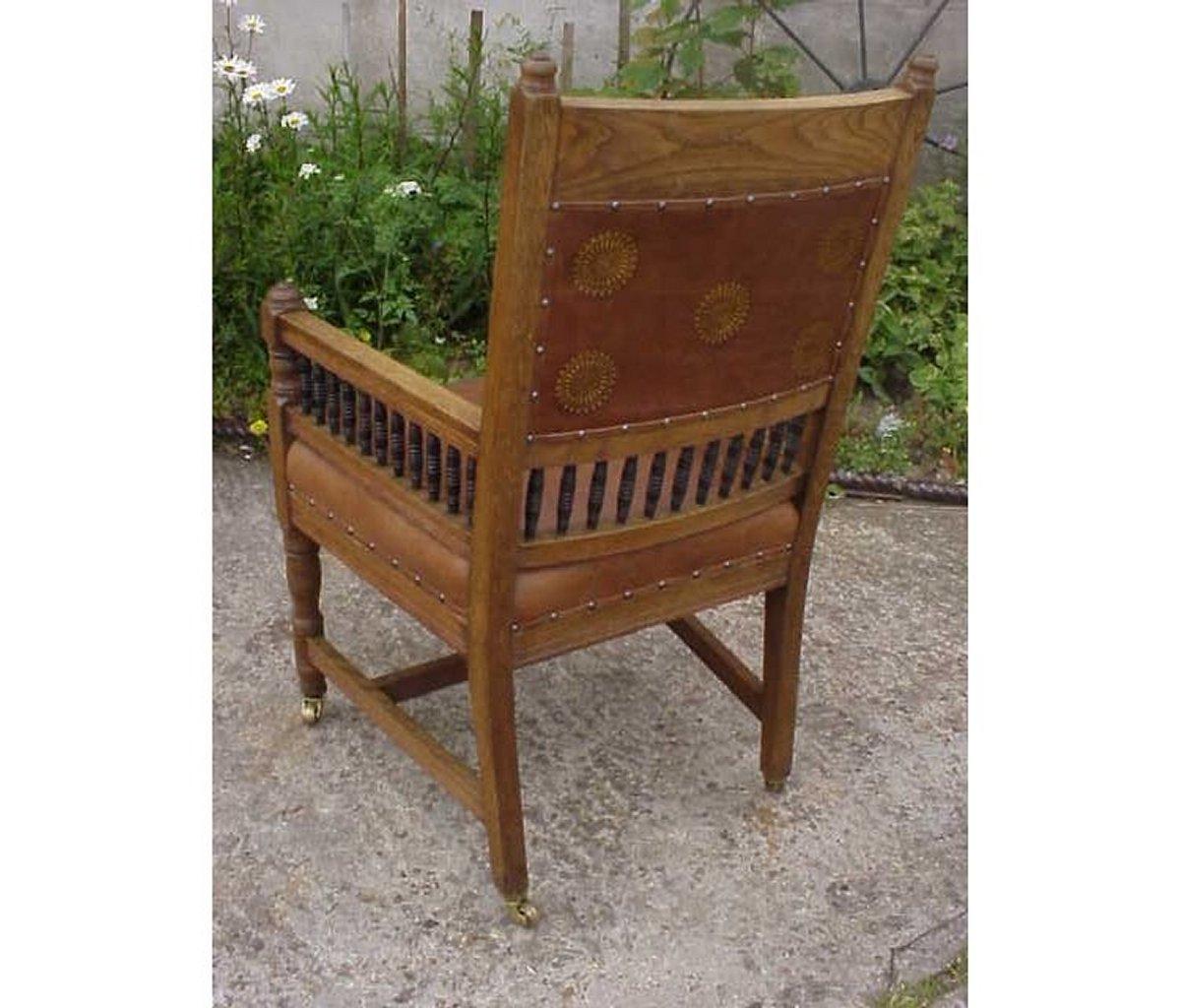 British E W Godwin. An Aesthetic Movement Carved Oak Armchair with Ebonized Spindles