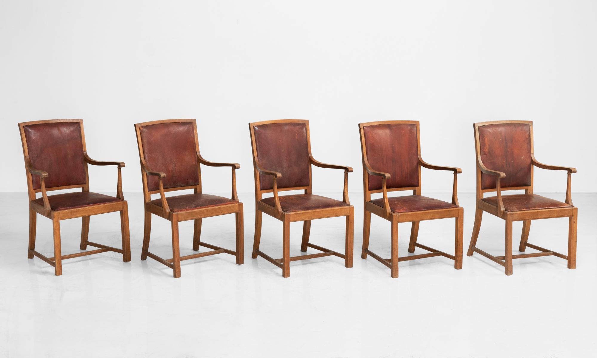 Carved oak and leather dining chairs, England, circa 1930.

Well-constructed armchairs with beautifully patinated leather backs and seat.