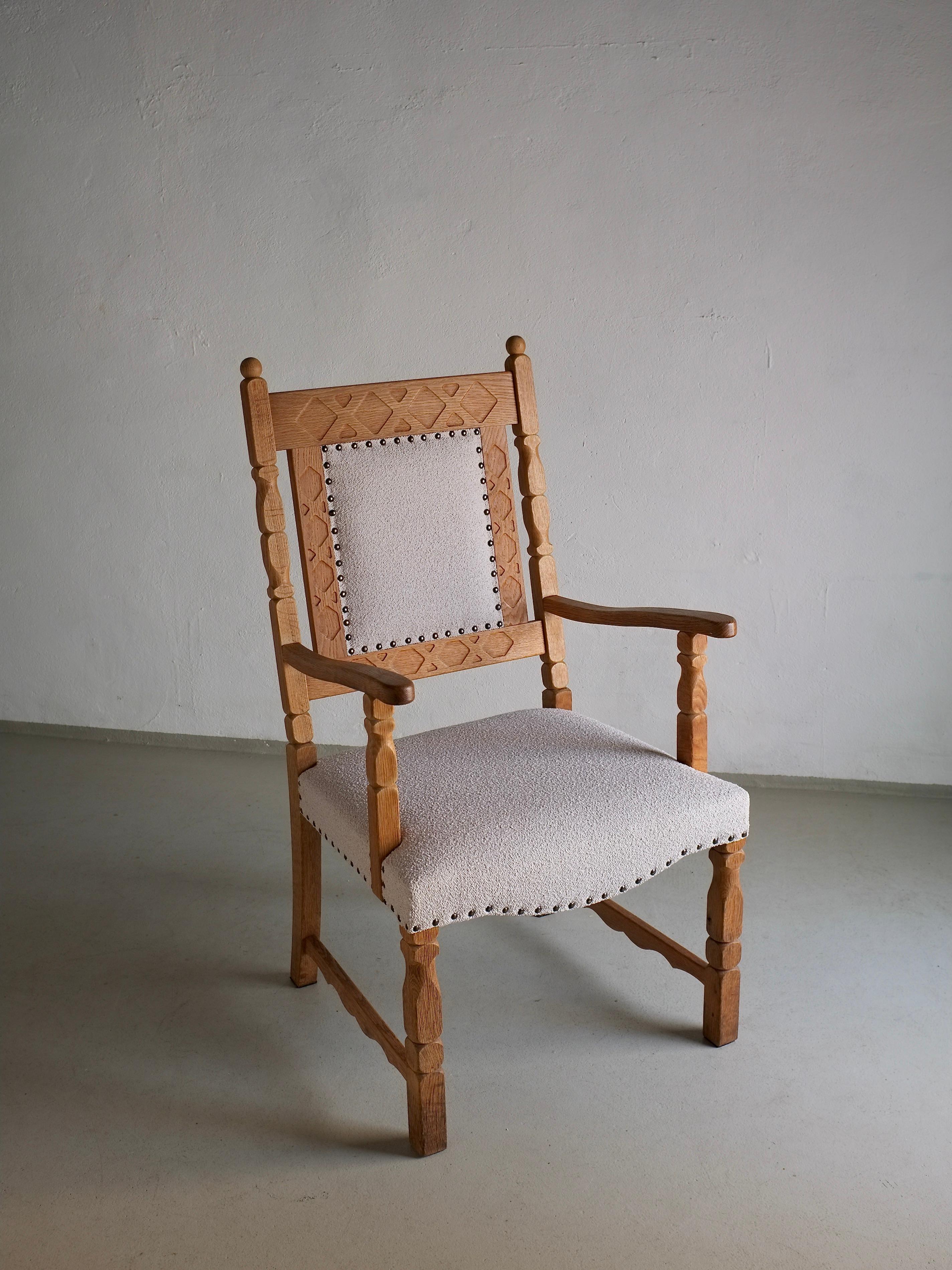 Sculptural carved oak armchair designed by Henning Kjaernulf in the 1960s, reupholstered with pearl-gray boucle fabric. Dimensions: H(total/armrest/seat) 106.5/70/44 cm, W 49 cm, D 48 cm