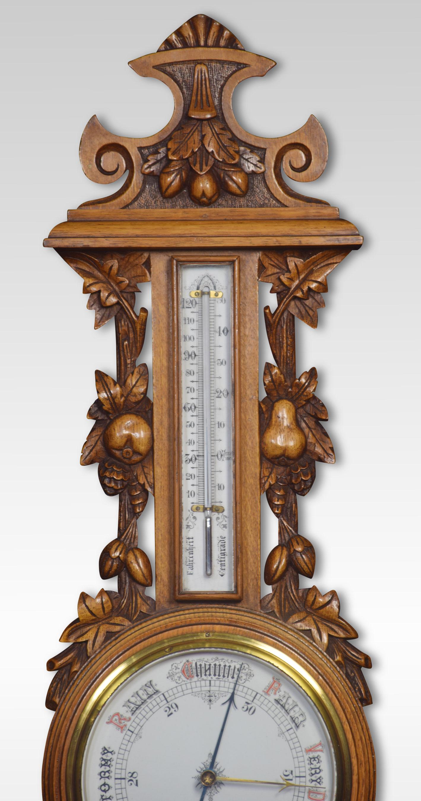 Carved oak wheel barometer, with a moulded pediment and scrolling decoration above a thermometer flanked by carved columns, the barometer with white enamel dial.
Dimensions:
Height 35 inches
Width 11 inches
Depth 3 inches.