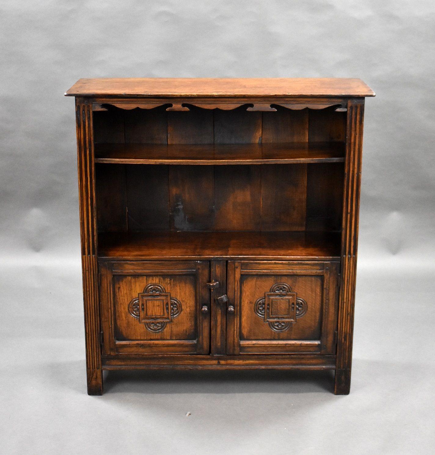 Carved oak bookcase/cabinet in good condition with shaped top, the cabinet has one shelf with cupboards below.