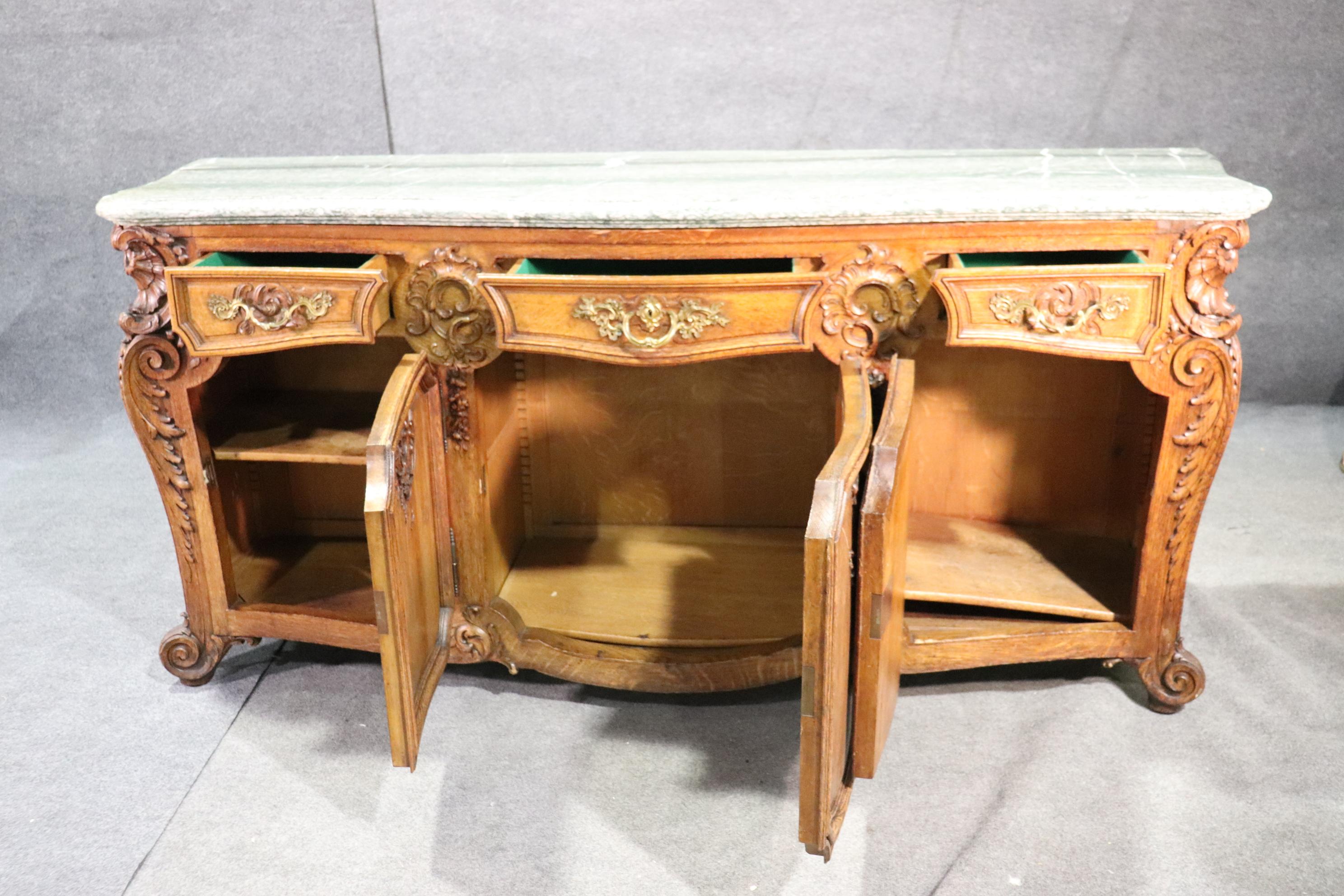 This is one of the finest sideboards we have had in many years. The finest oak carving that can be found on any French piece. The marble is extremely thick and heavy, much thicker than the ones we normally see. The piece is in excellent condition