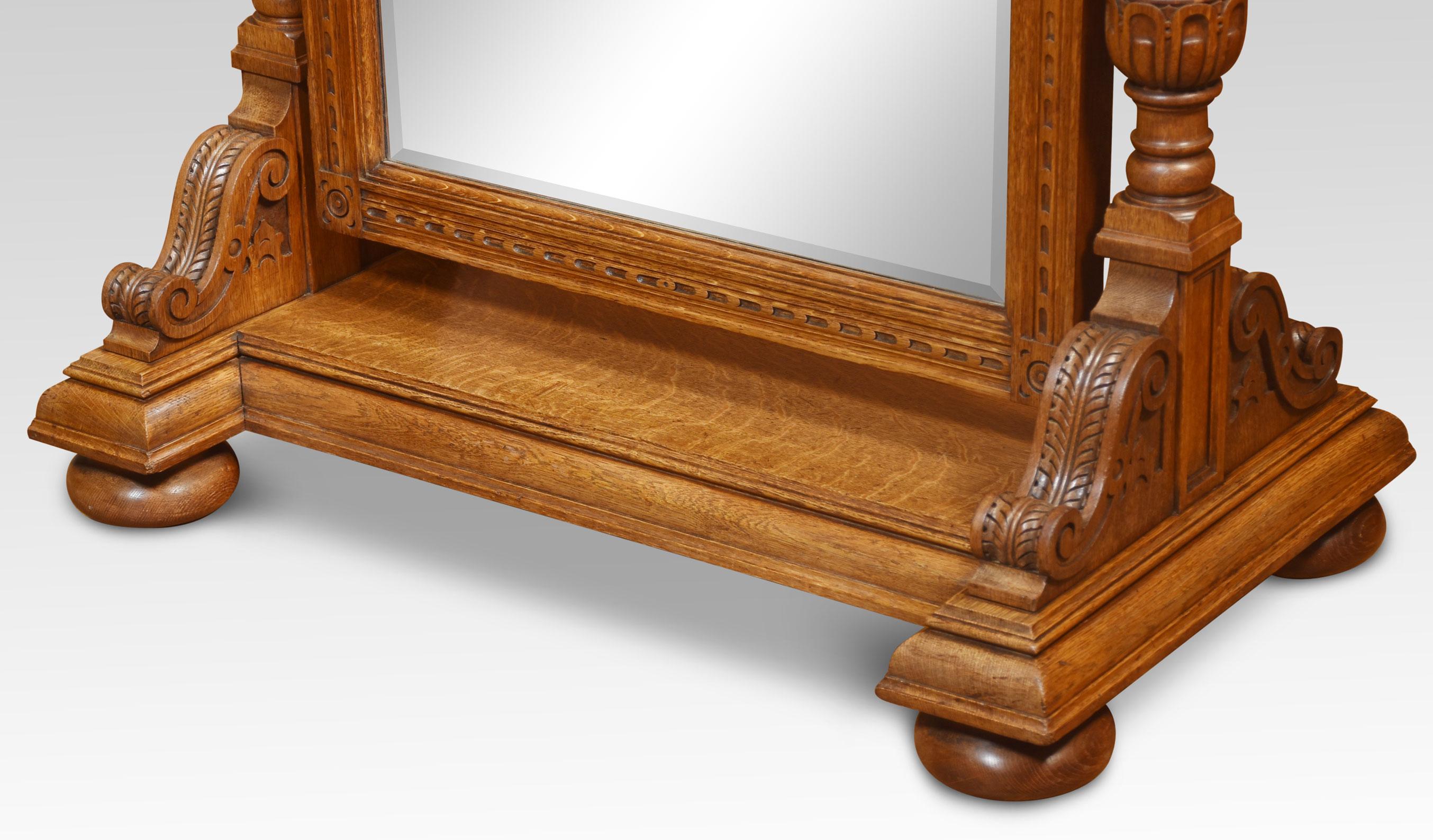 Large oak cheval dressing mirror having scrolling cornicing above an arched bevelled mirror plate and fluted frame, supported by a pair of architectural form columns over an inverted breakfront base with acanthus corbels and large compressed bun