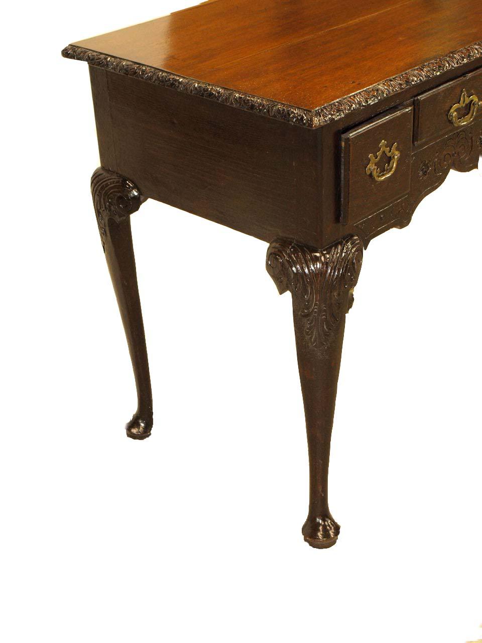 Carved oak Chippendale style lowboy, nicely faded top with carved molding, the three drawers with overlapping beaded edges and open work original pulls. The apron features carved rosettes and foliate. All four cabriole legs with highly carved knees