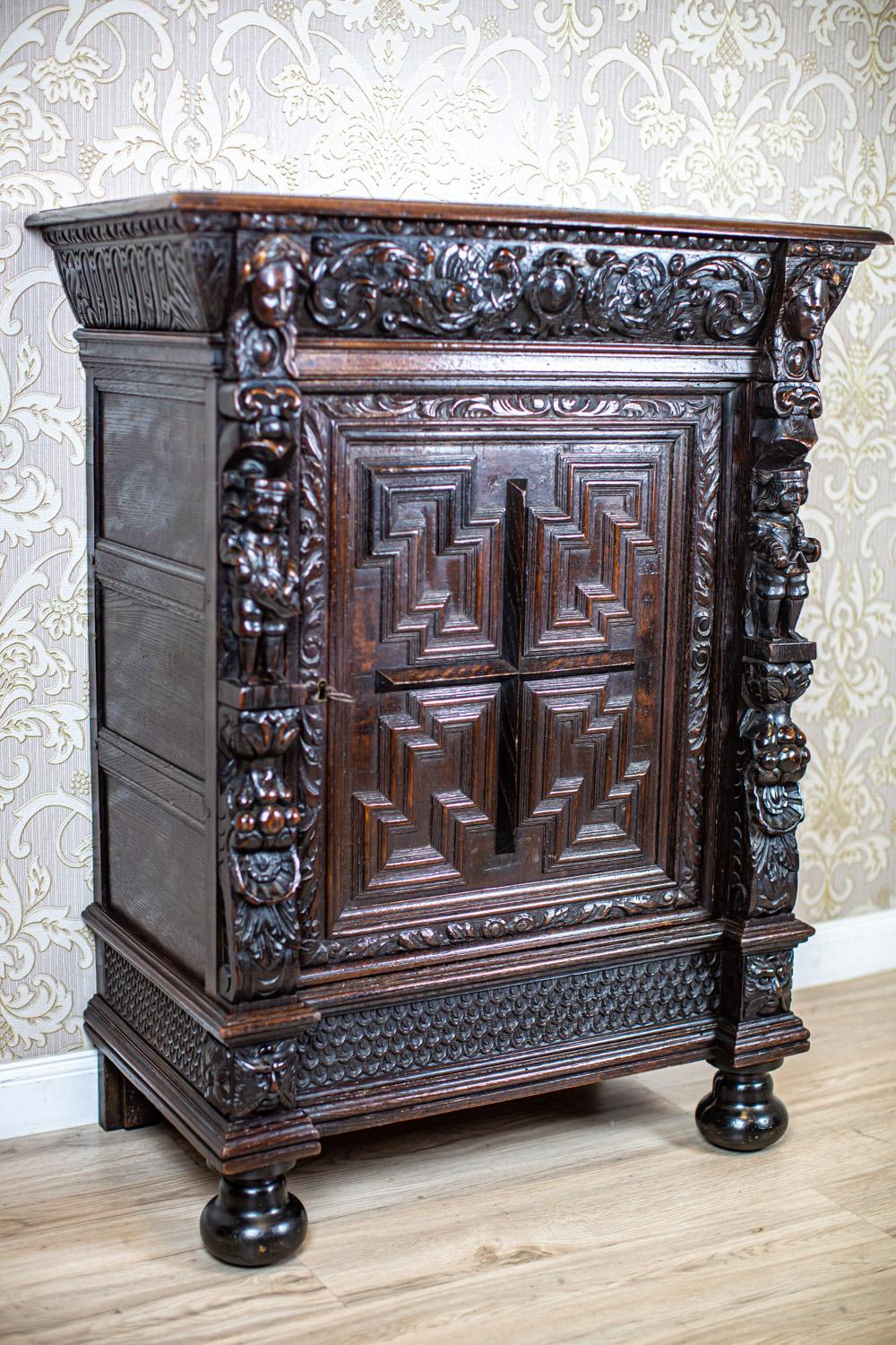 Kommode aus massivem geschnitztem Eichenholz aus dem späten 19. Jahrhundert

Einflügeliger Aufbau mit Gesims und einer einzigen Schublade, die oben mit einer Tischplatte abgedeckt ist. Die Vorderseite der Möbel ist mit reichen Schnitzereien