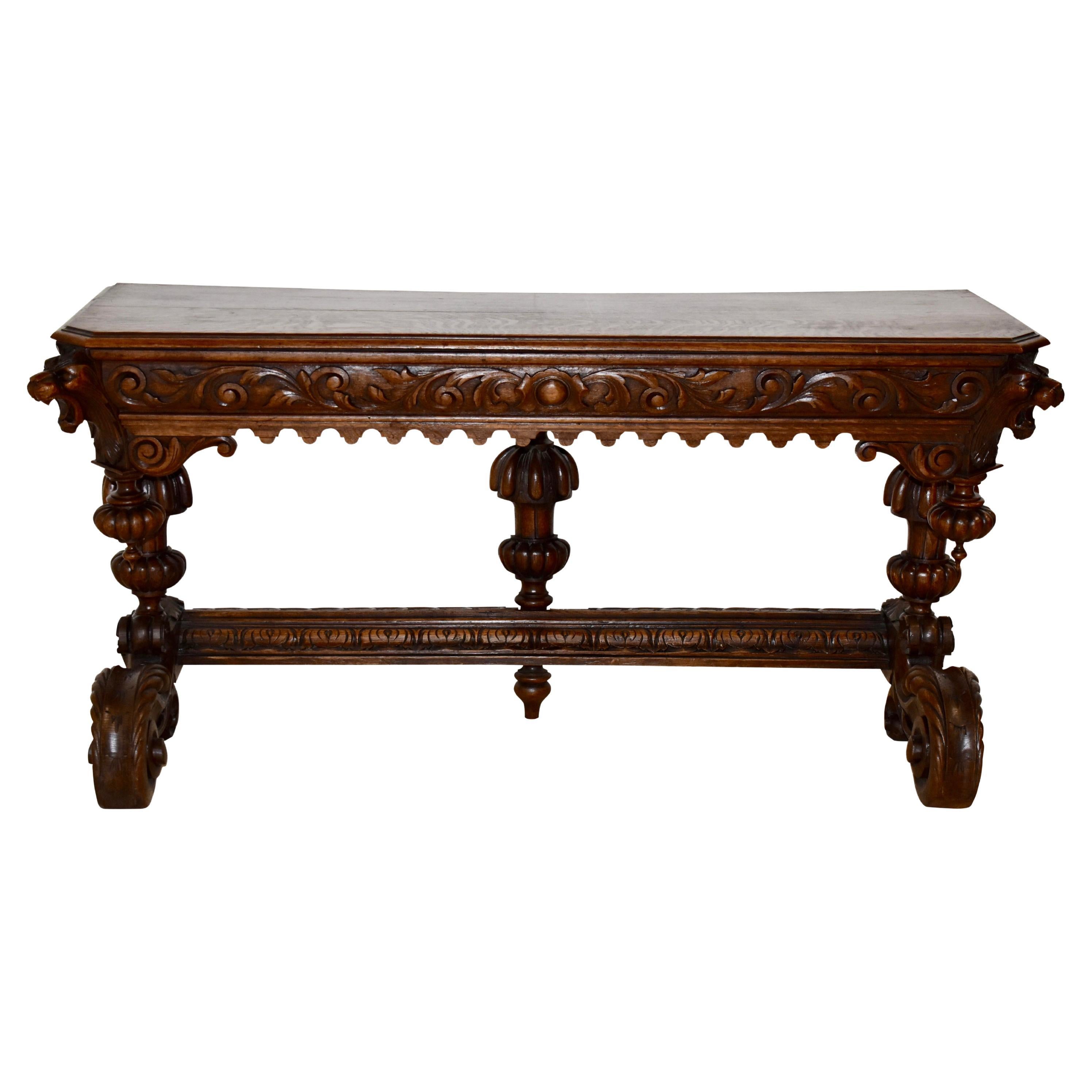 Crafted from oak and finished with a dark stain. this beautiful console table from the late-19th century adds elegance to any room. It features a beveled top with canted corners; bulbous, melon cup and cover legs; a decorative stretcher; and large