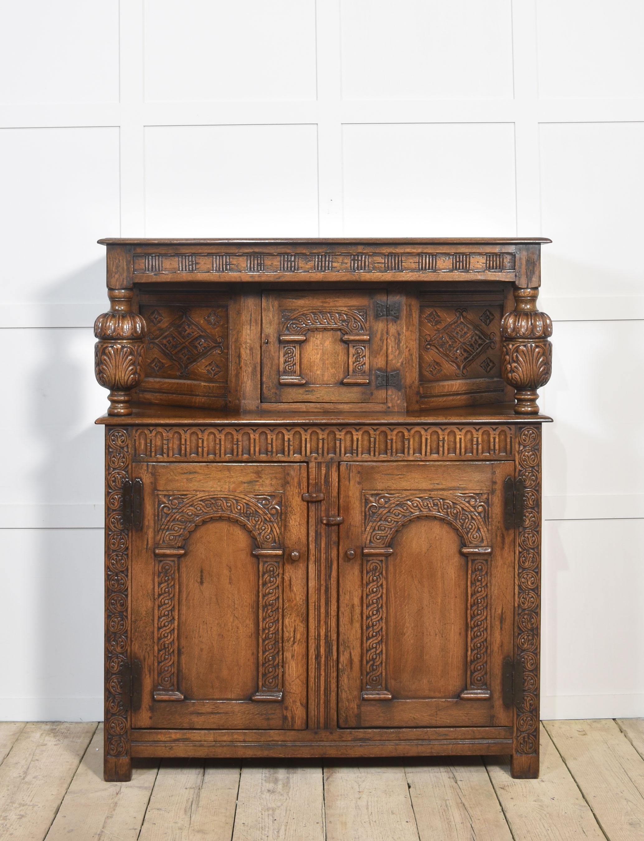 Armoire de cour en chêne, l'armoire cannelée sculptée et lambrissée reposant sur des supports tournés en forme de coupe et de couvercle et sur une frise à arcades. La partie inférieure comporte deux portes cintrées à panneaux qui s'ouvrent pour