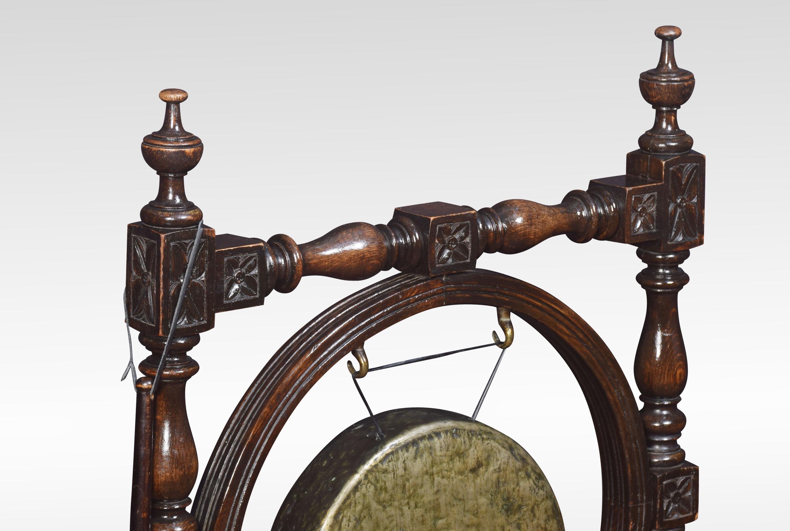 Carved oak dinner gong, the frame with turned finials above carved frame supporting the circular brass gong. Raised up on carved trestle base, together with the striker.
Dimensions:
Height 38 inches
Width 27 inches
Depth 12 inches.
