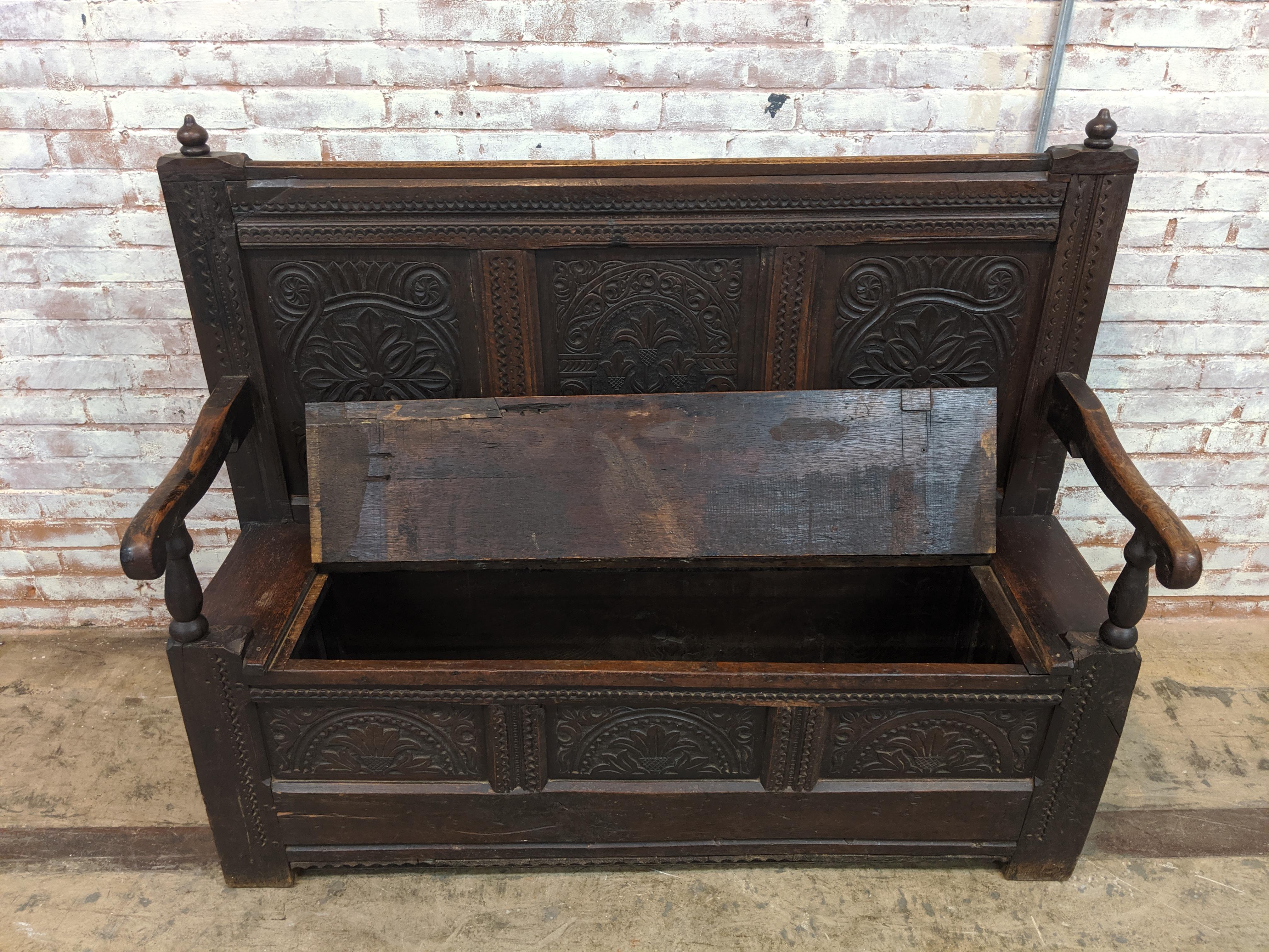 Beautiful 19th century Victorian carved oak English settle bench. Sometimes referred to as a monk's bench. It has wonderful carvings throughout and a storage area beneath the seat. Measures 53