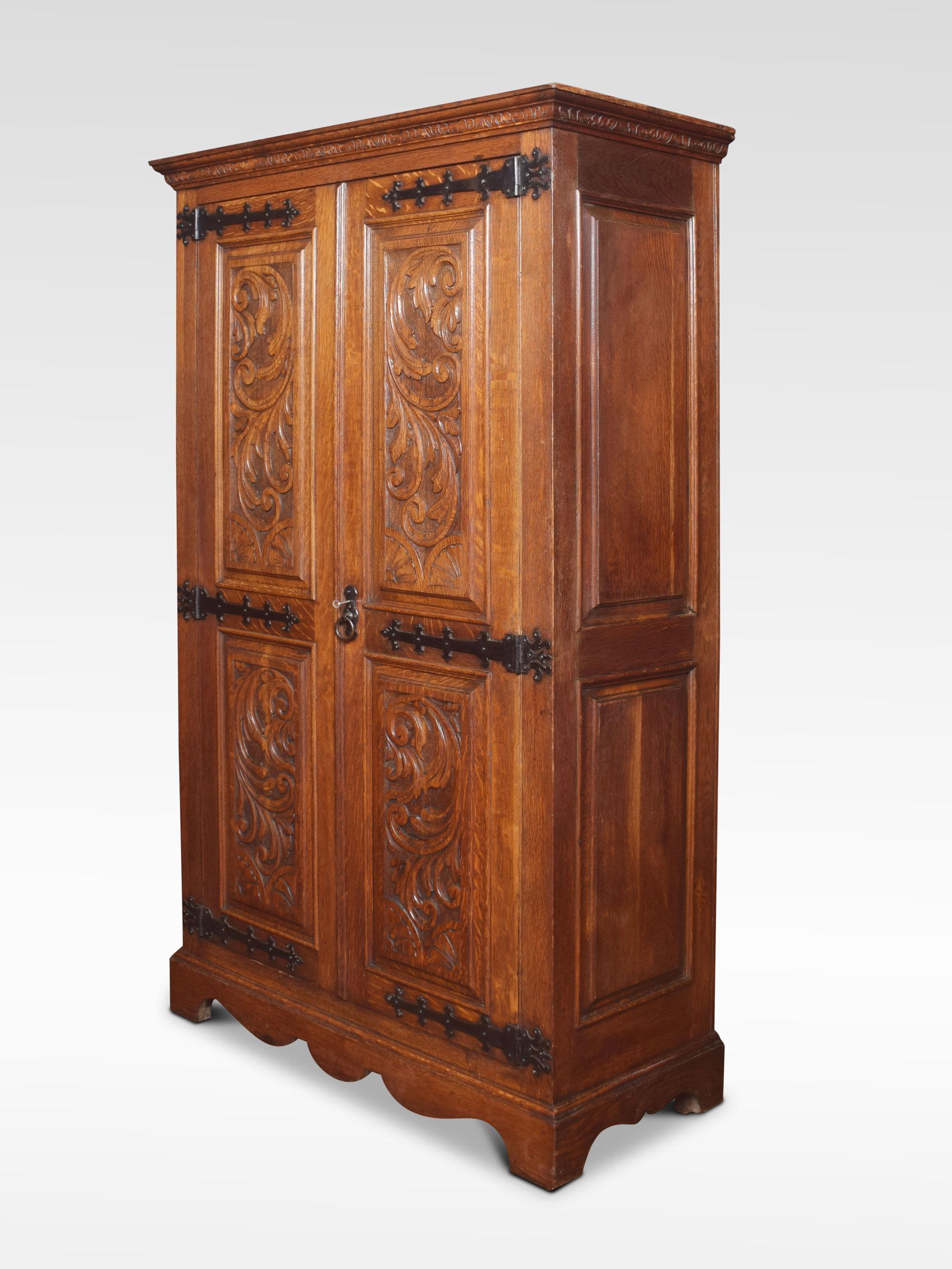 Carved oak two-door wardrobe the projecting cornice above two carved paneled doors with scrolling foliage and original strapwork hinges. The large doors opening to reveal a hanging area. All raised up on bracket feet.
Dimensions:
Height 71