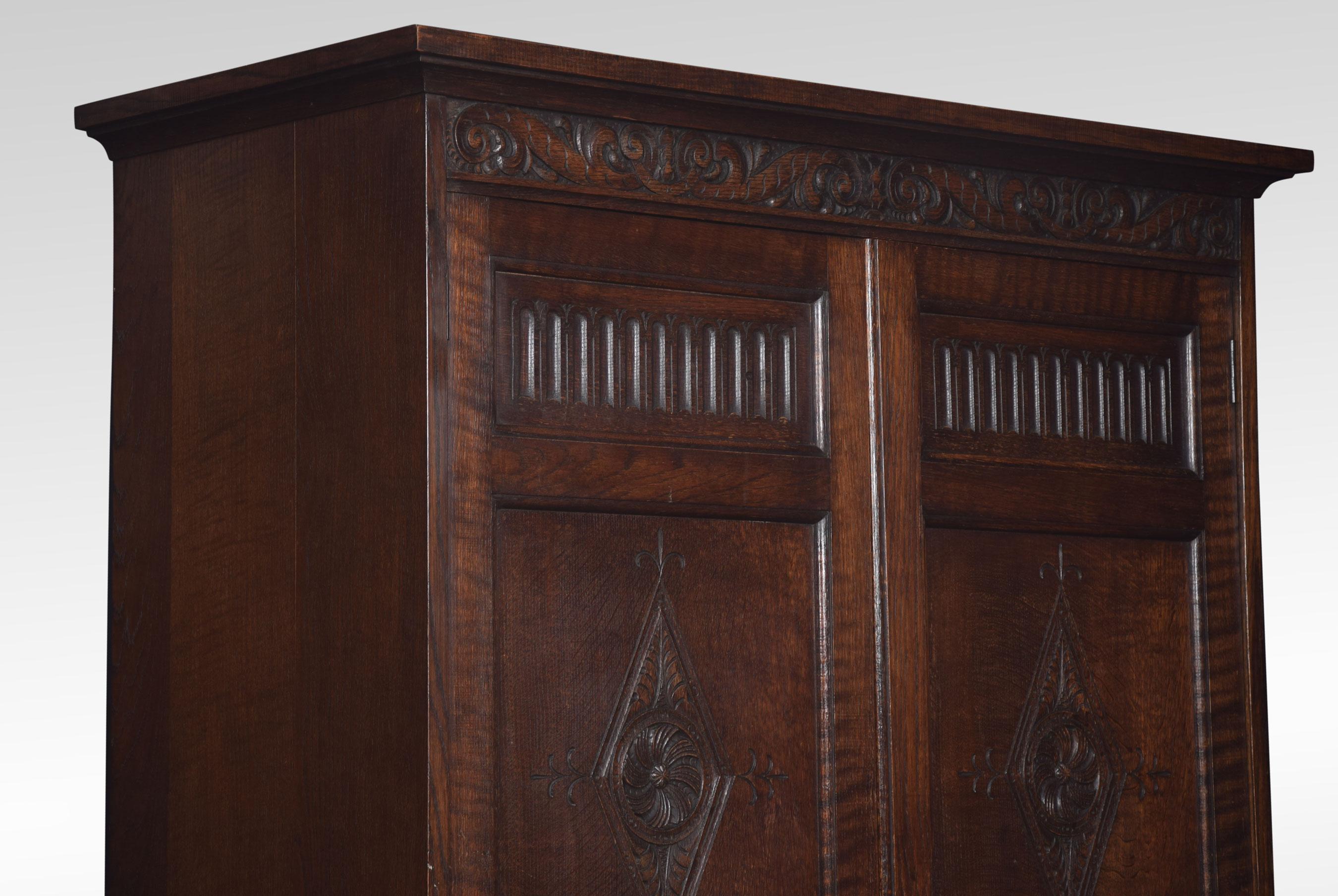 Solid oak two-door wardrobe, the molded cornice above carved geometric doors opening to reveal hanging area. To the base fitted with a long drawer. All raised up on bracket feet.
Dimensions
Height 72 inches
Length 45 inches
width 20.5 inches.