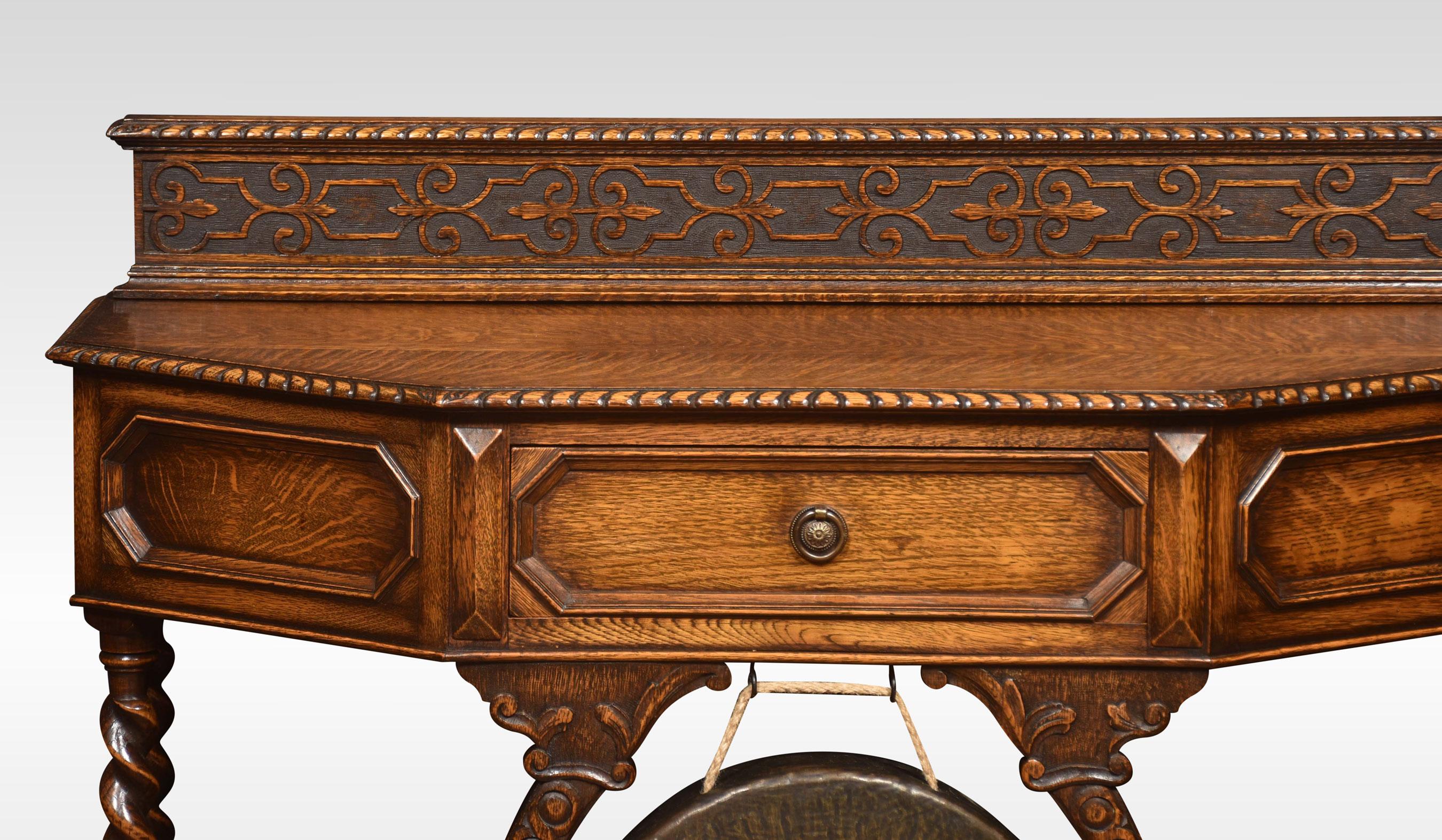 Carved oak hall table of rectangular form with canted corners above a geometric moulded central drawer with brass gong below. Raised up on spiral-turned supports united by under tier. All raised up on bun feet.
Dimensions
Height 35 Inches
Width