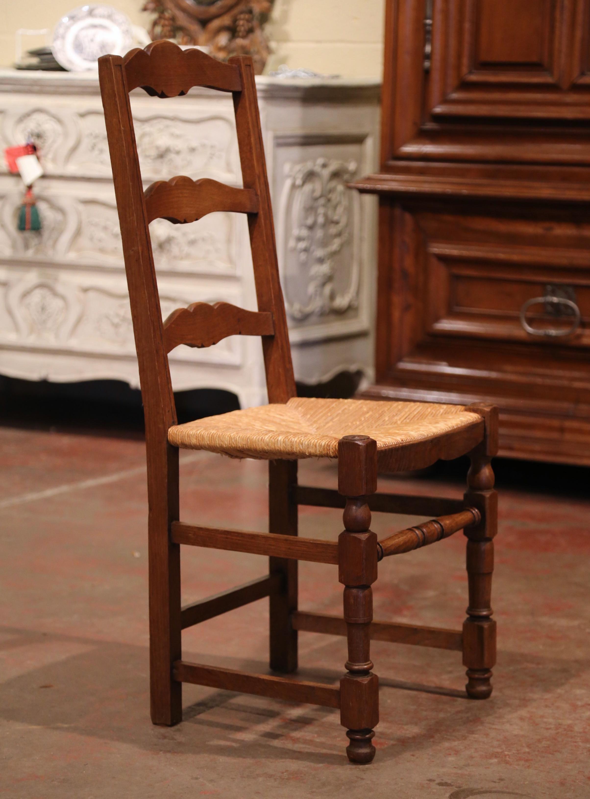 These eight elegant country chairs were crafted in Normandy France, circa 1980. Carved from solid oak, each chair has three scalloped ladders across the pitched back which give each chair great support and comfort. The seat has woven rush surface