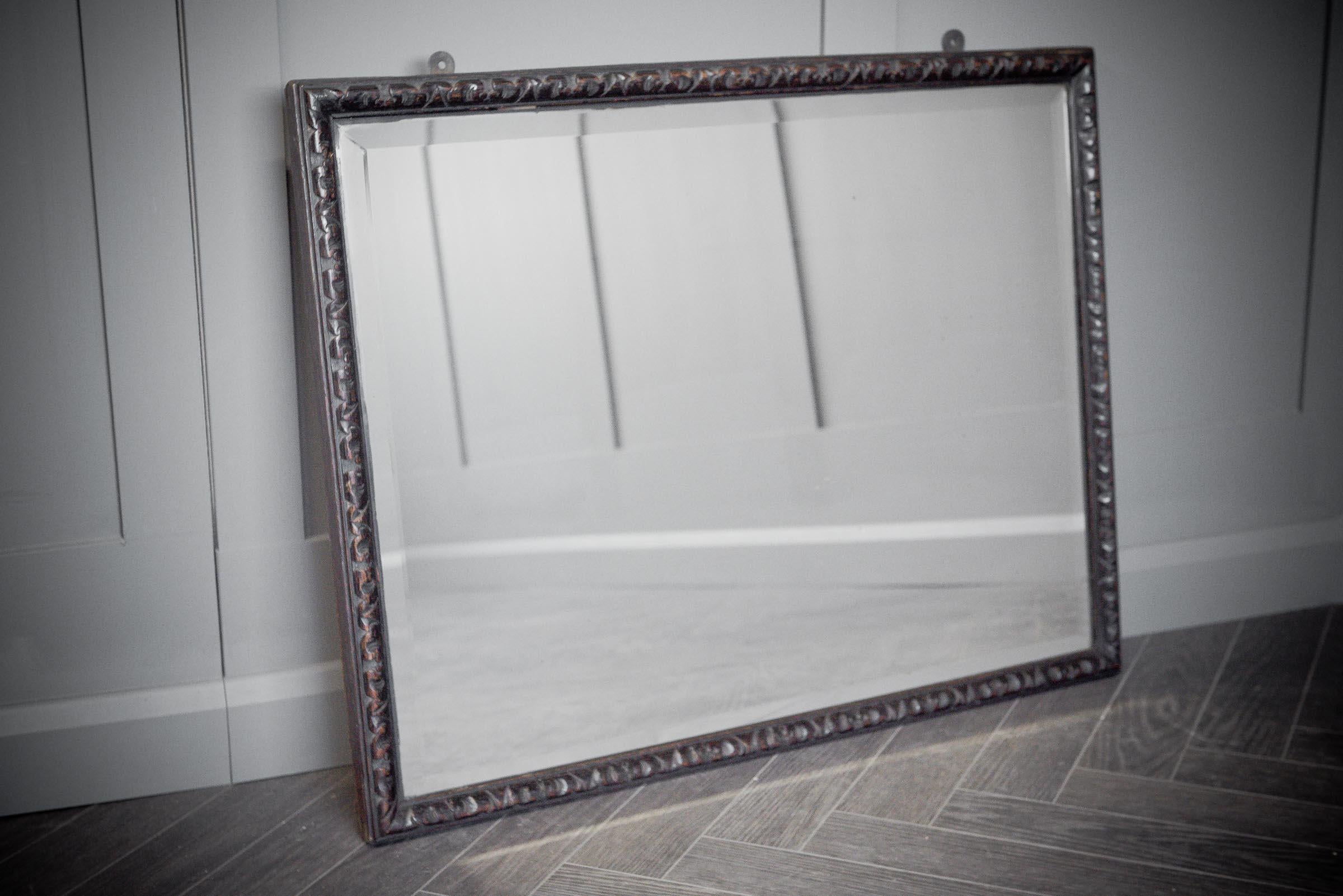 A beautifully carved oak mirror with leaf like detailing. 