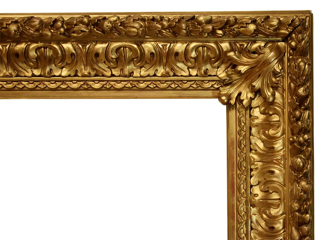 This larger frame is carved wood with gold leaf and gesso ornamentation, using an oak leaf design as its motif inspiration. Small berries and flowers adorn both the inner and outer edges. 

**The dimensions provided represent the inner space