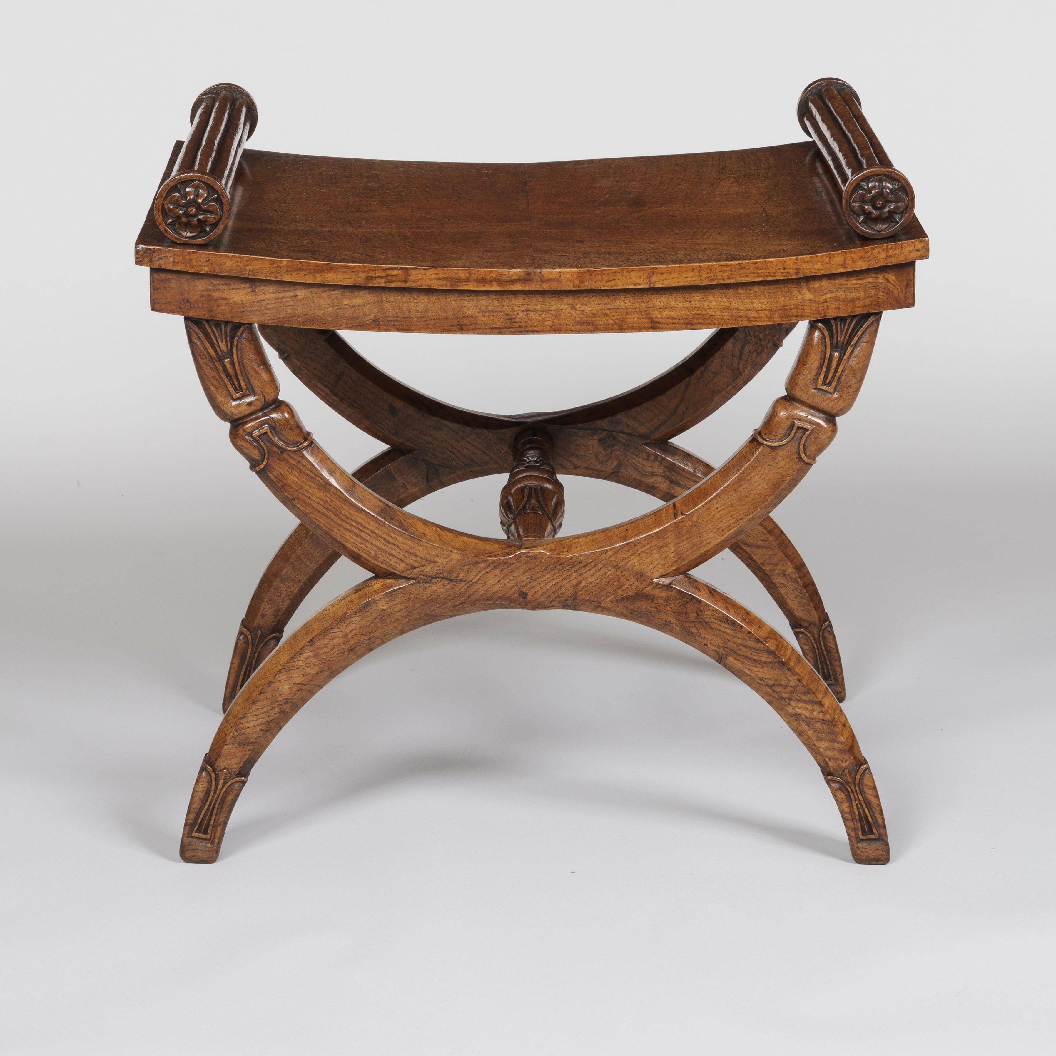 A Regency period X-frame stool
Possibly by George Bullock

Constructed from indigenous oak--a wood typically used by the renowned cabinetmaker George Bullock--this stool of elegant proportions supported on x-frame supports carved with lotus ends