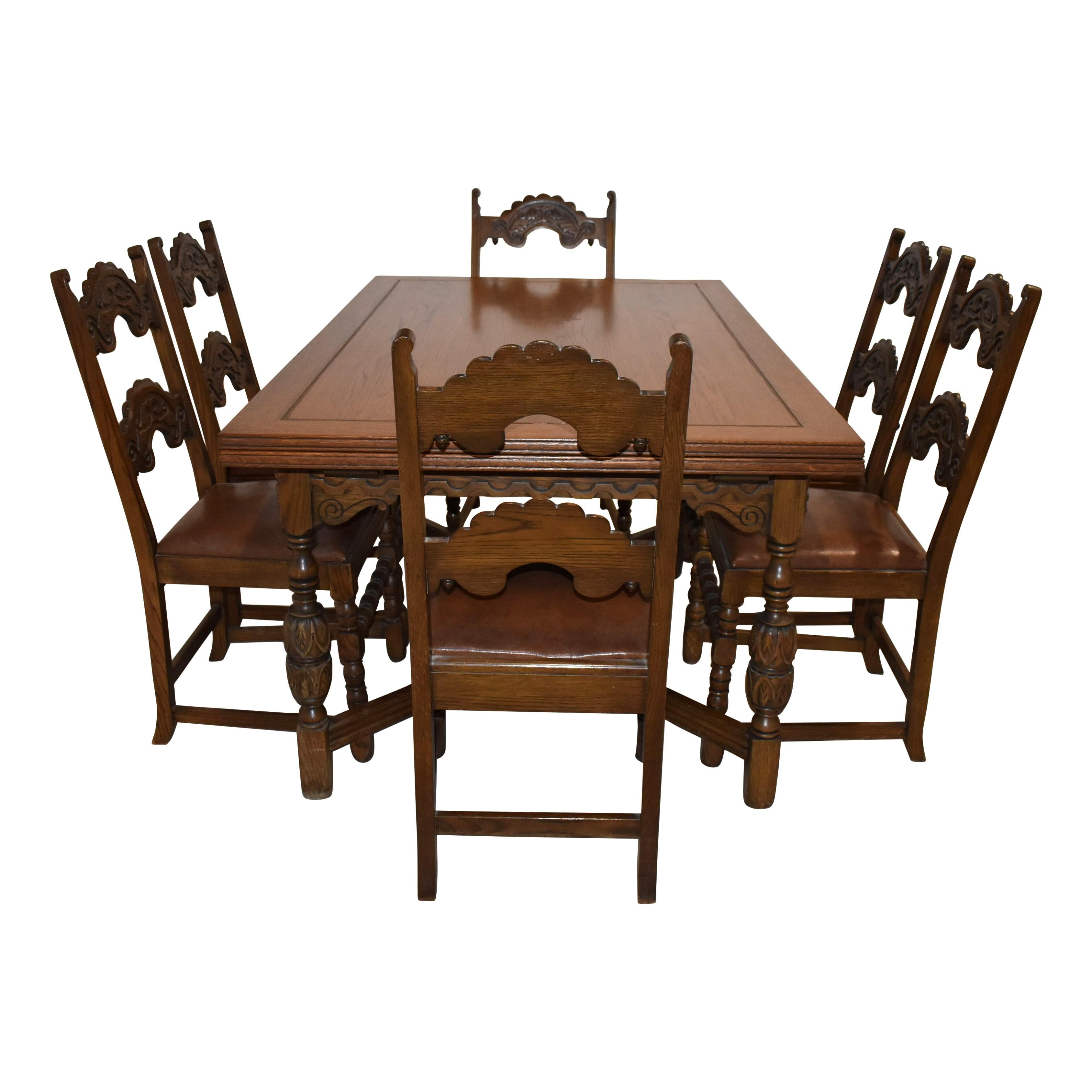 Questo bellissimo set da pranzo intagliato è stato prodotto dalla Rockford Chair & Furniture Company all'inizio del XX secolo. Realizzato in Oak e rifinito con una tinta scura, è composto da un tavolo e sei sedie. Il tavolo è dotato di ante nascoste