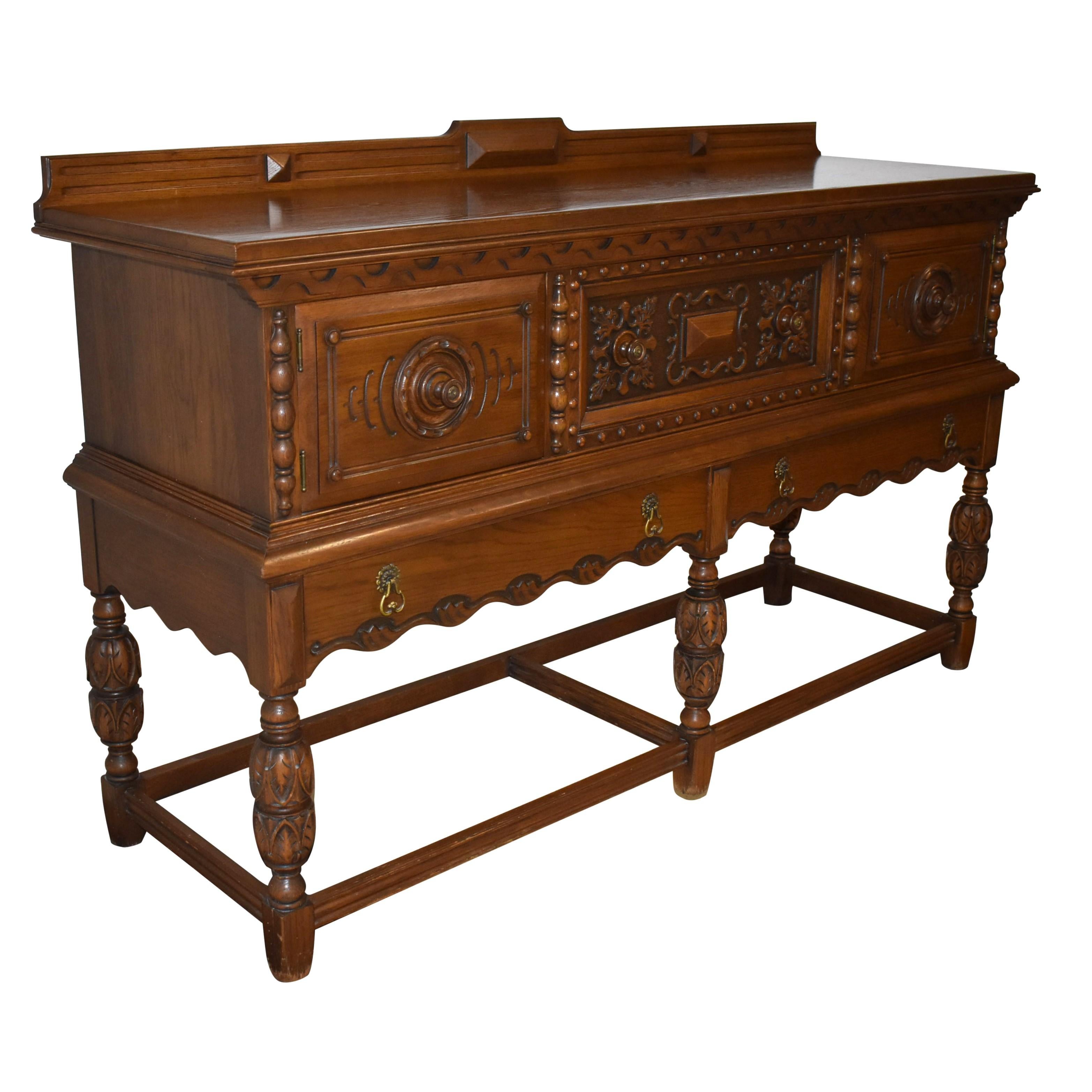 Dieses schöne geschnitzte Sideboard wurde von der Rockford Chair & Furniture Company Anfang des 20. Jahrhunderts hergestellt. Das aus Eiche gefertigte und dunkel gebeizte Möbelstück verfügt über eine mittlere Schublade, die von Türen flankiert wird,
