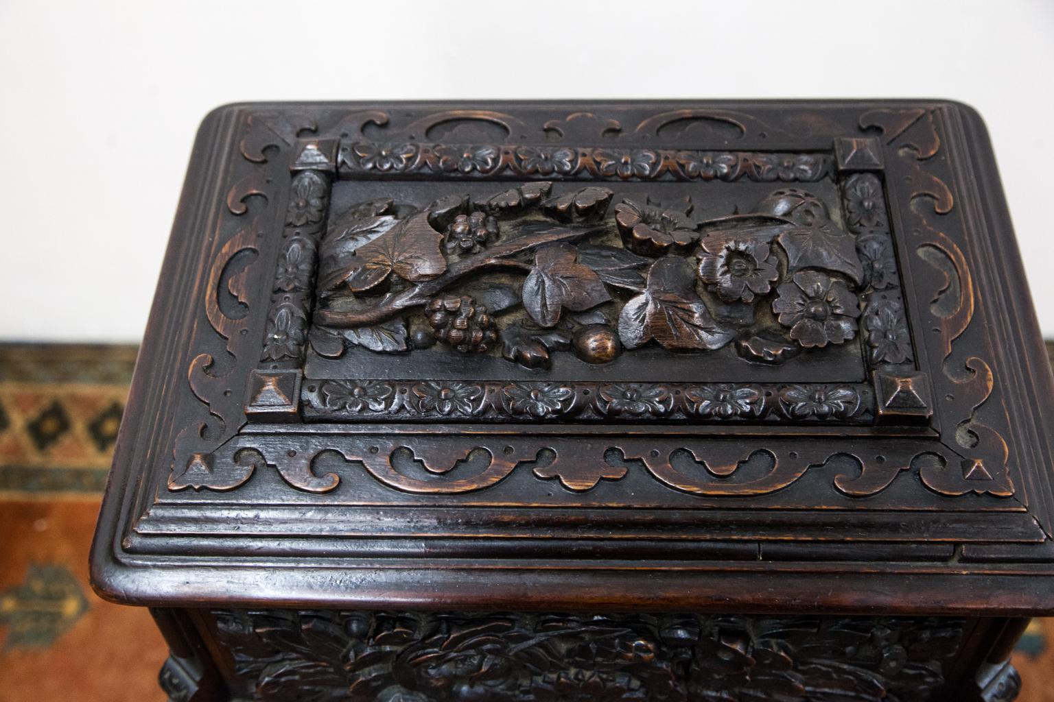 Carved oak tea caddy on pedestal base, the four sided caddy has floral and grapevine carvings in high relief, barley twist shaft on carved rectangular base.