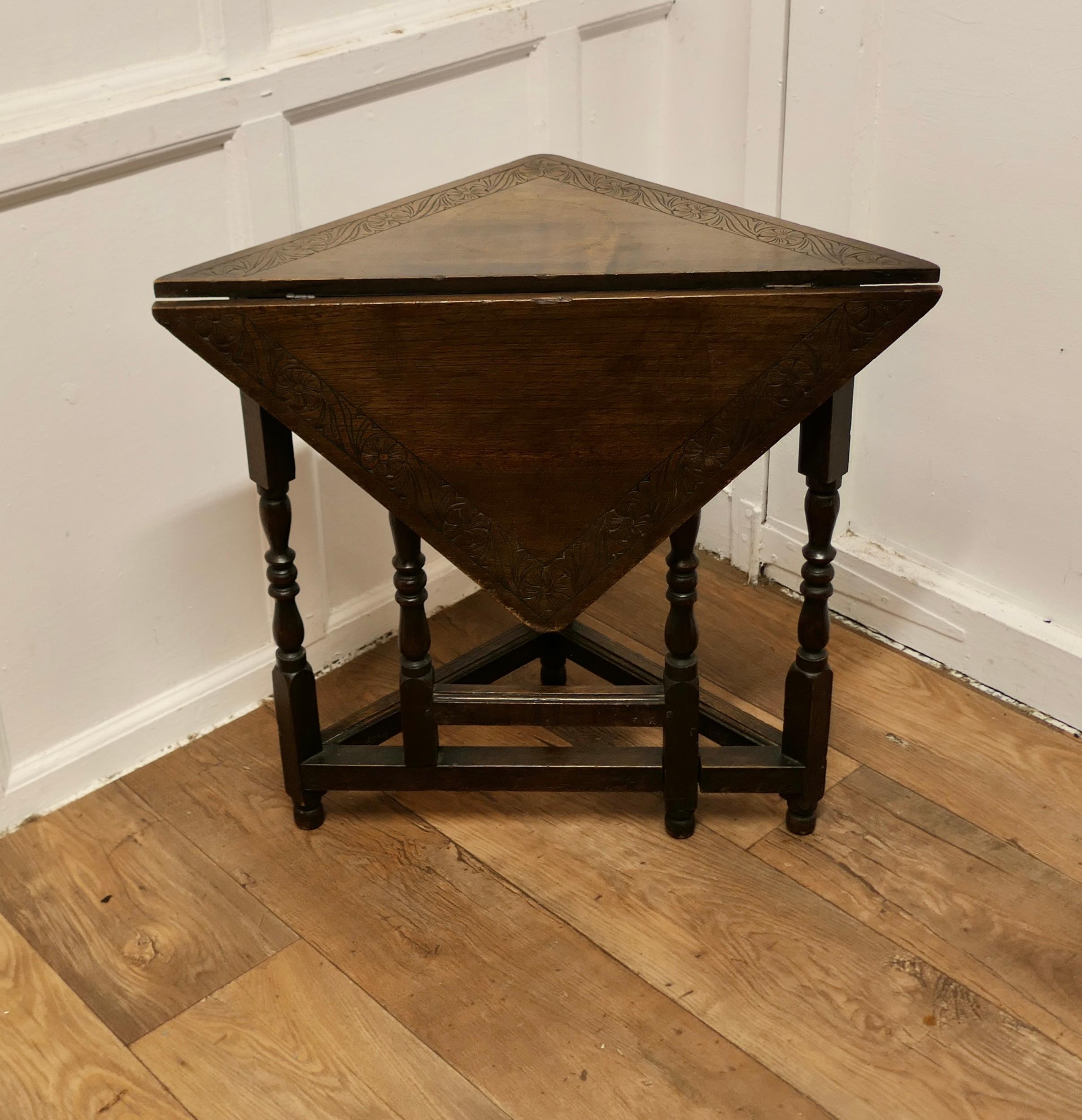 Carved Oak Triangular Gate Leg Side Table

A pretty and very useful little piece, this is a corner table with a drop flap and a gate support
The table top has a carved border and turned legs it is in good sound condition with a few old bumps
The