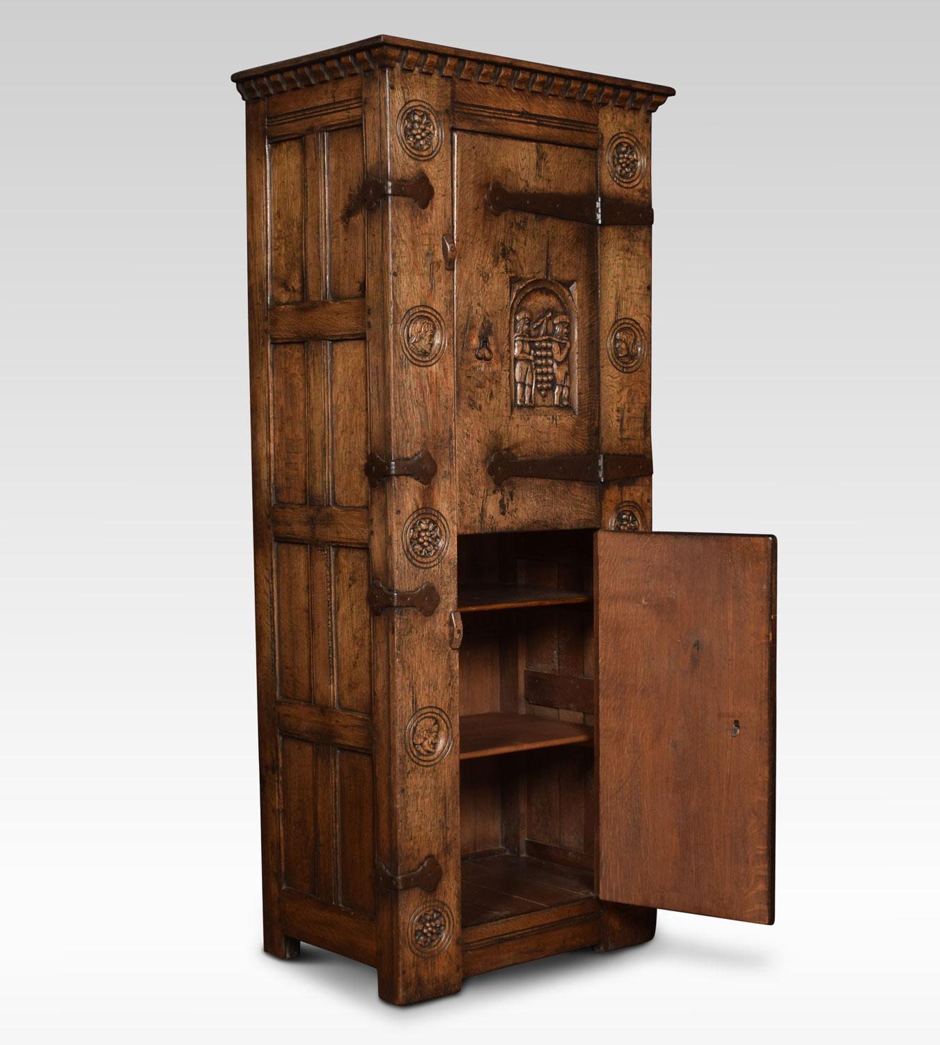 Oak cupboard, the moulded top above twin figure and shield motif doors with large iron strap hinges. Opening to reveal a shelved interior. The stylised roundels depicting Roman heads and Tudor roses.
Dimensions:
Height 70.5 inches
Width 33