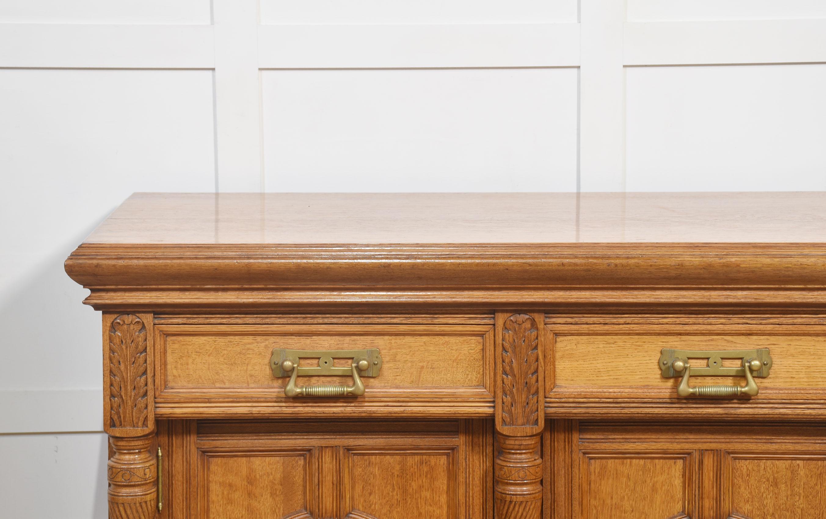 British Carved oak two door sideboard by Maple and Co For Sale
