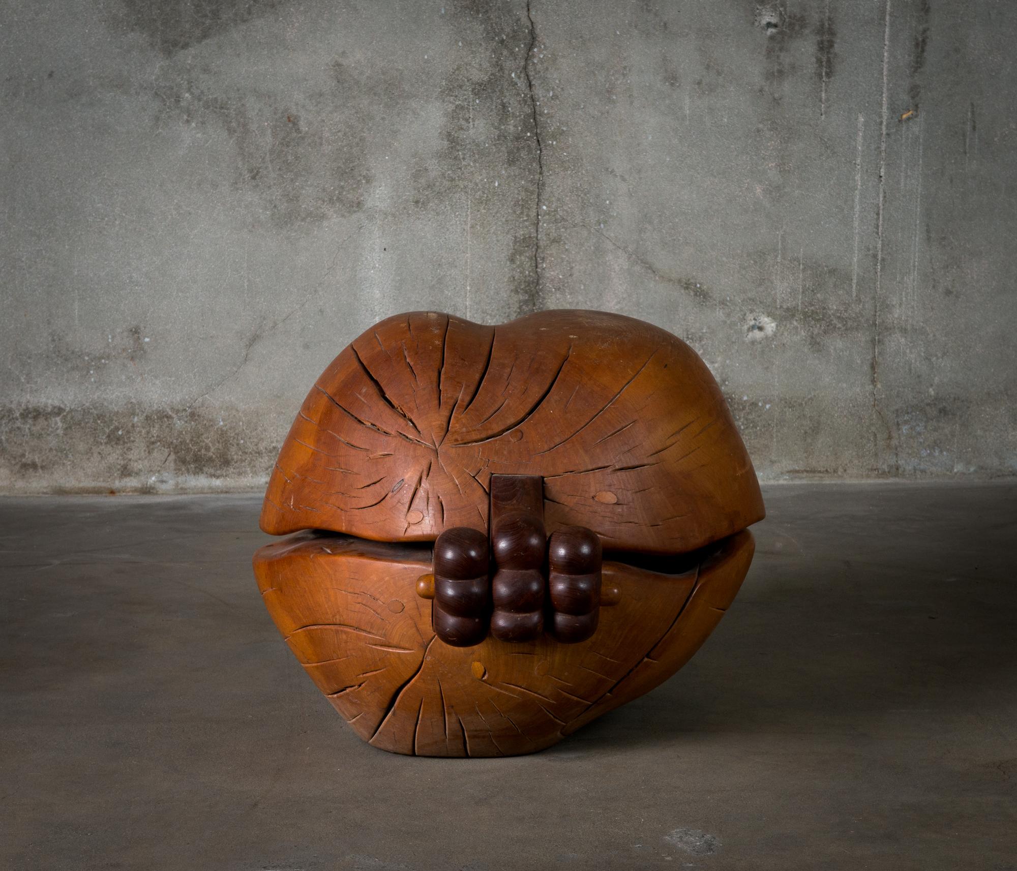 A carved wood container with carved wood oblong object within, by Jon Brooks (b.1944).