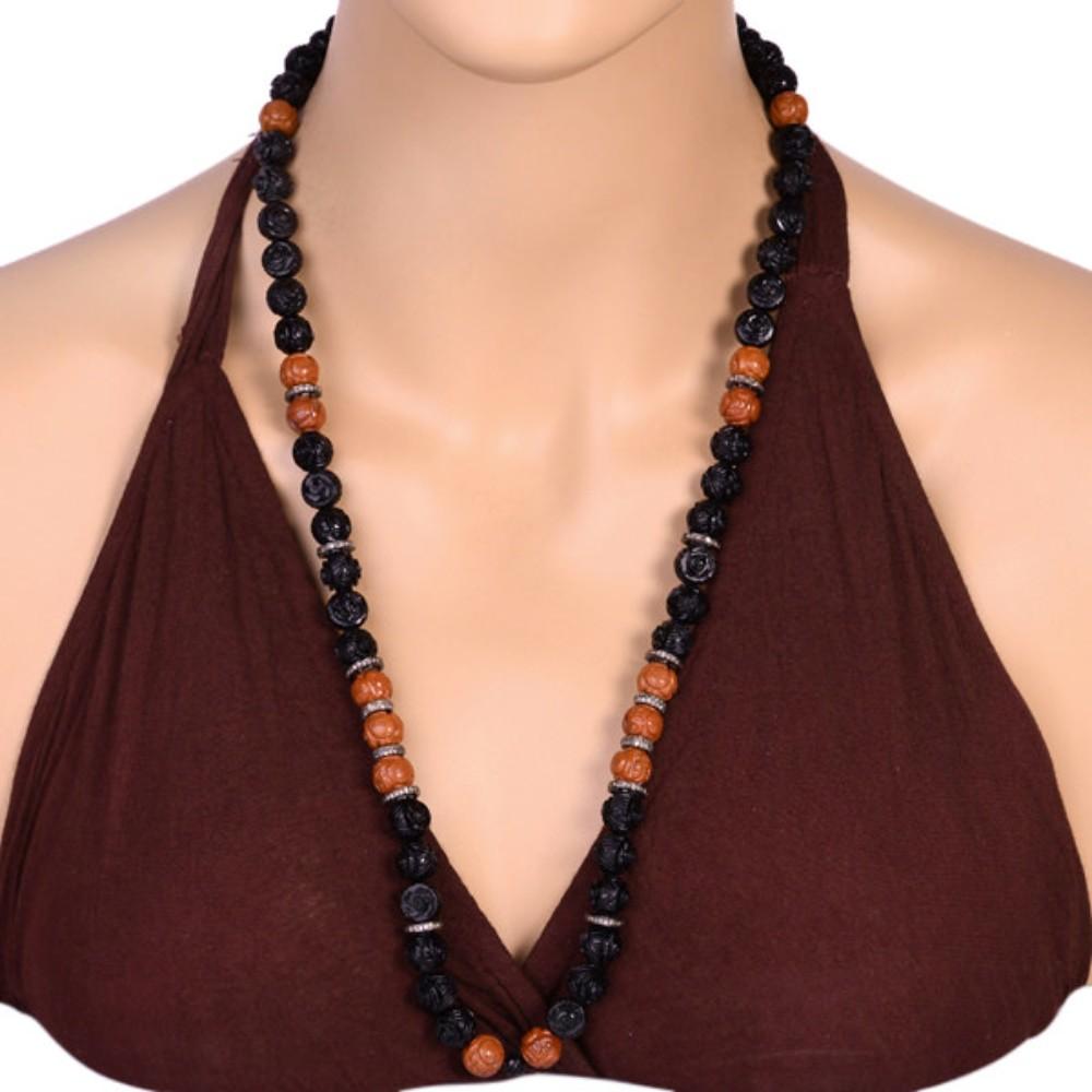 Diese atemberaubende Halskette besteht aus geschnitzten Onyx- und Jaspisperlen, die an einer Silberkette aufgereiht sind. Die Halskette ist mit funkelnden Diamanten verziert, die ihr einen Hauch von Eleganz und Luxus verleihen. Diese Halskette ist