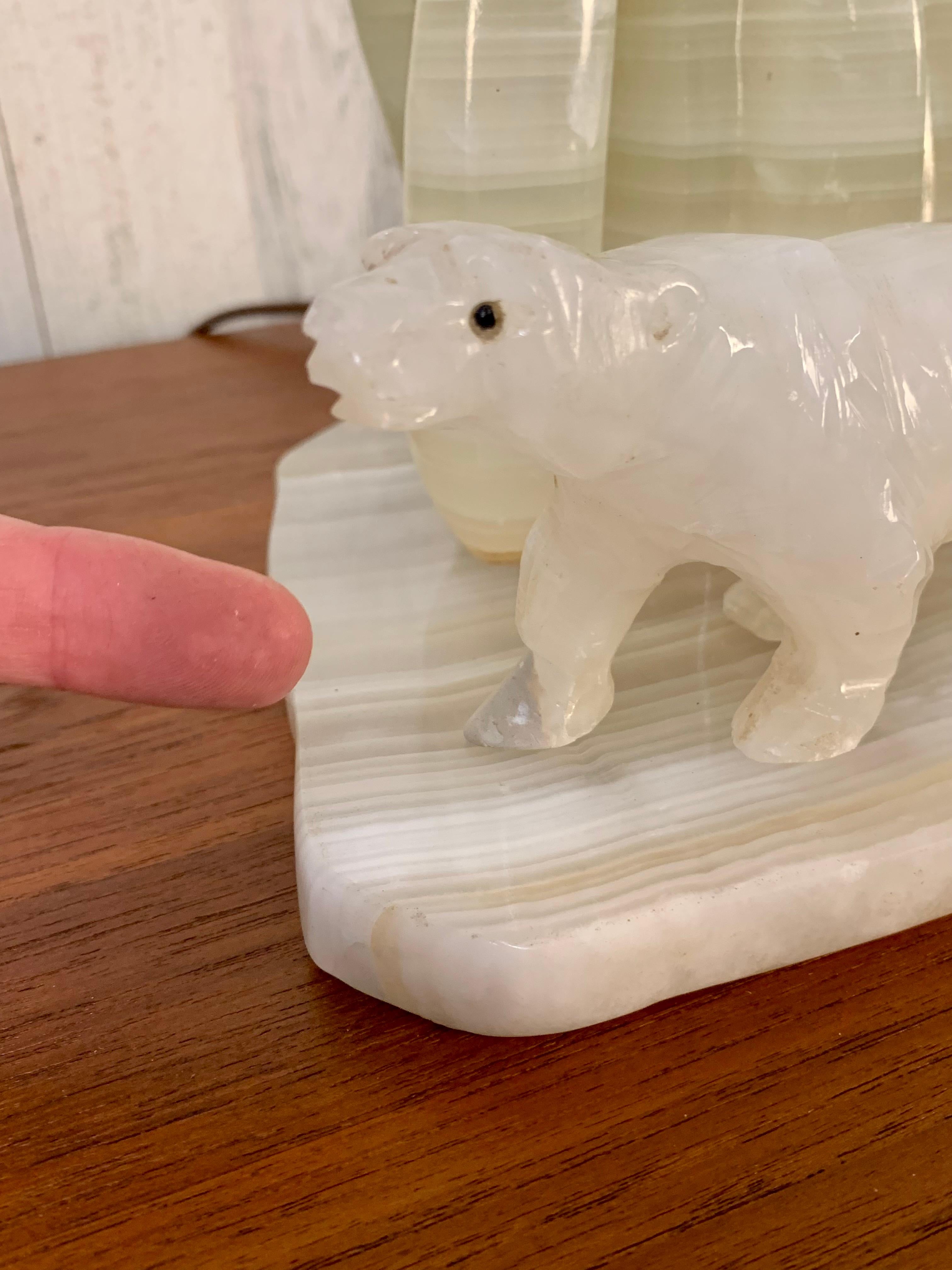 White and green onyx carved into an iceberg with one bear looking down on another bear.
One small light bulb illuminates from the inside.