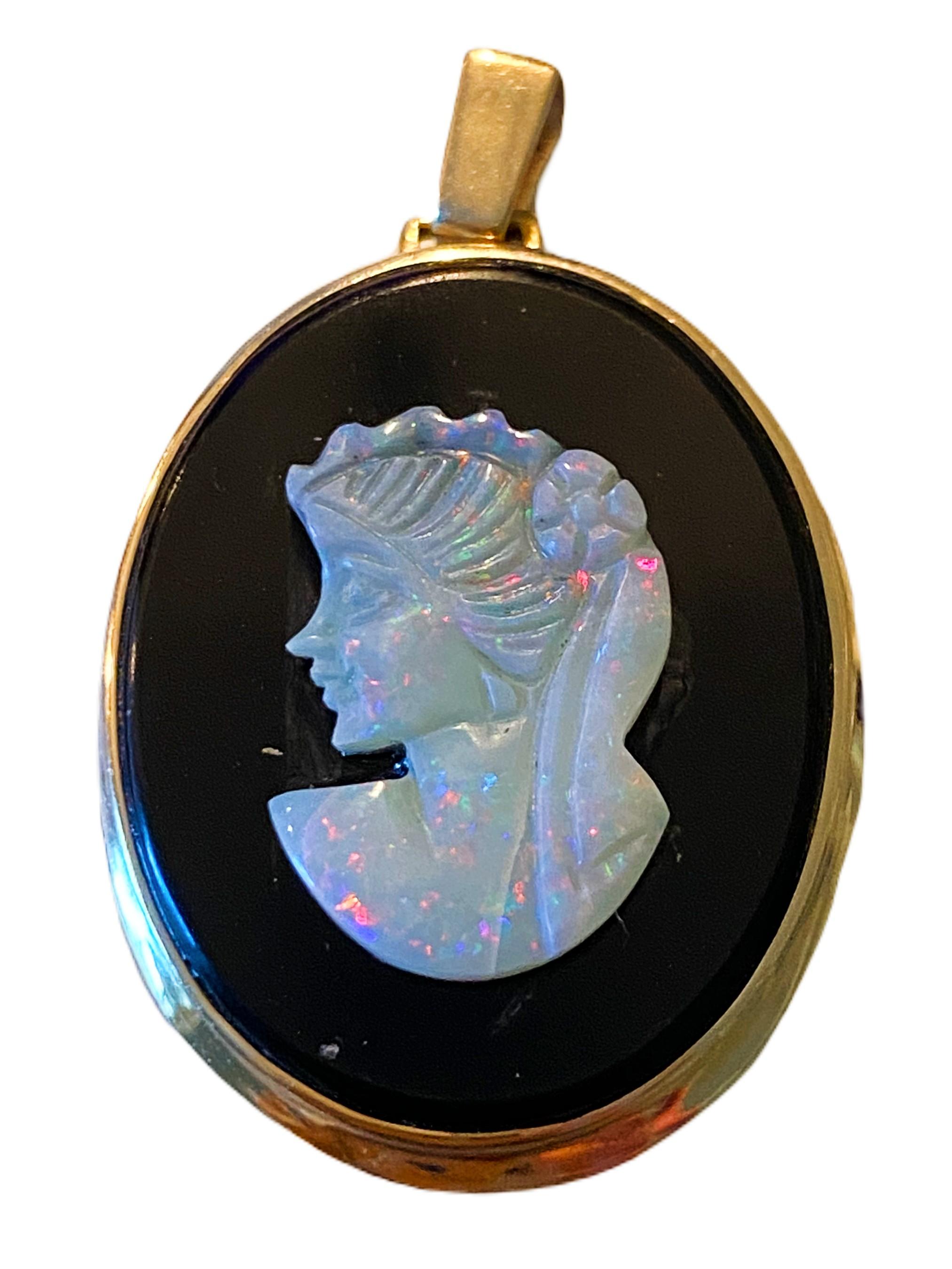 An exquisite Vintage Carved Opal Cameo Pendant, a lovely piece of mid-century artistry that showcases the ethereal beauty of opal and the timeless elegance of cameo jewelry. Crafted with precision and set in 14k yellow gold, this pendant is a true