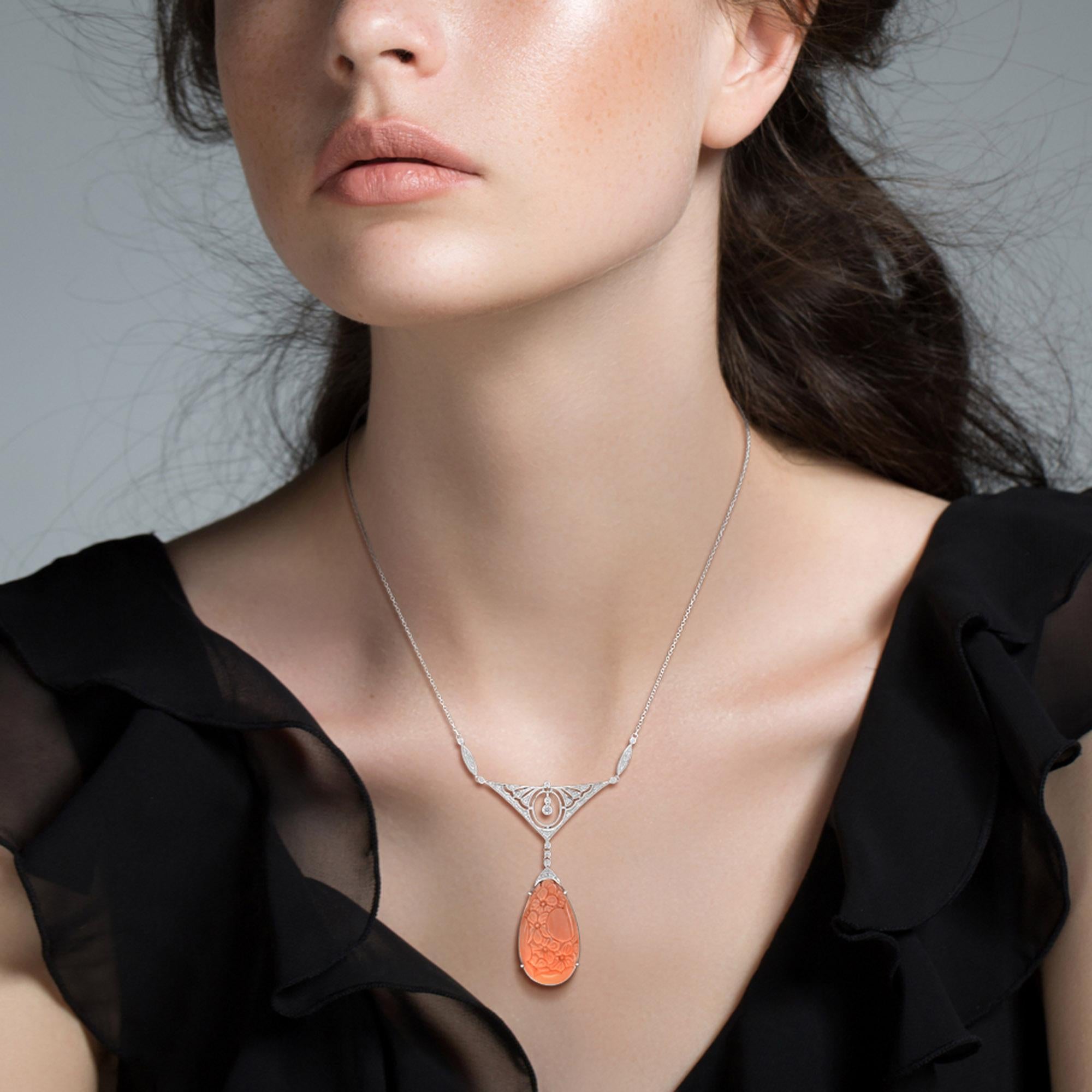Sensational necklace is stunning with a carved coral and diamonds in an Art Deco style. The teardrop shape coral is carved with floral motif hanging from the top part featured approx. 0.32 carat diamonds, all set in 14k white gold. Chic,