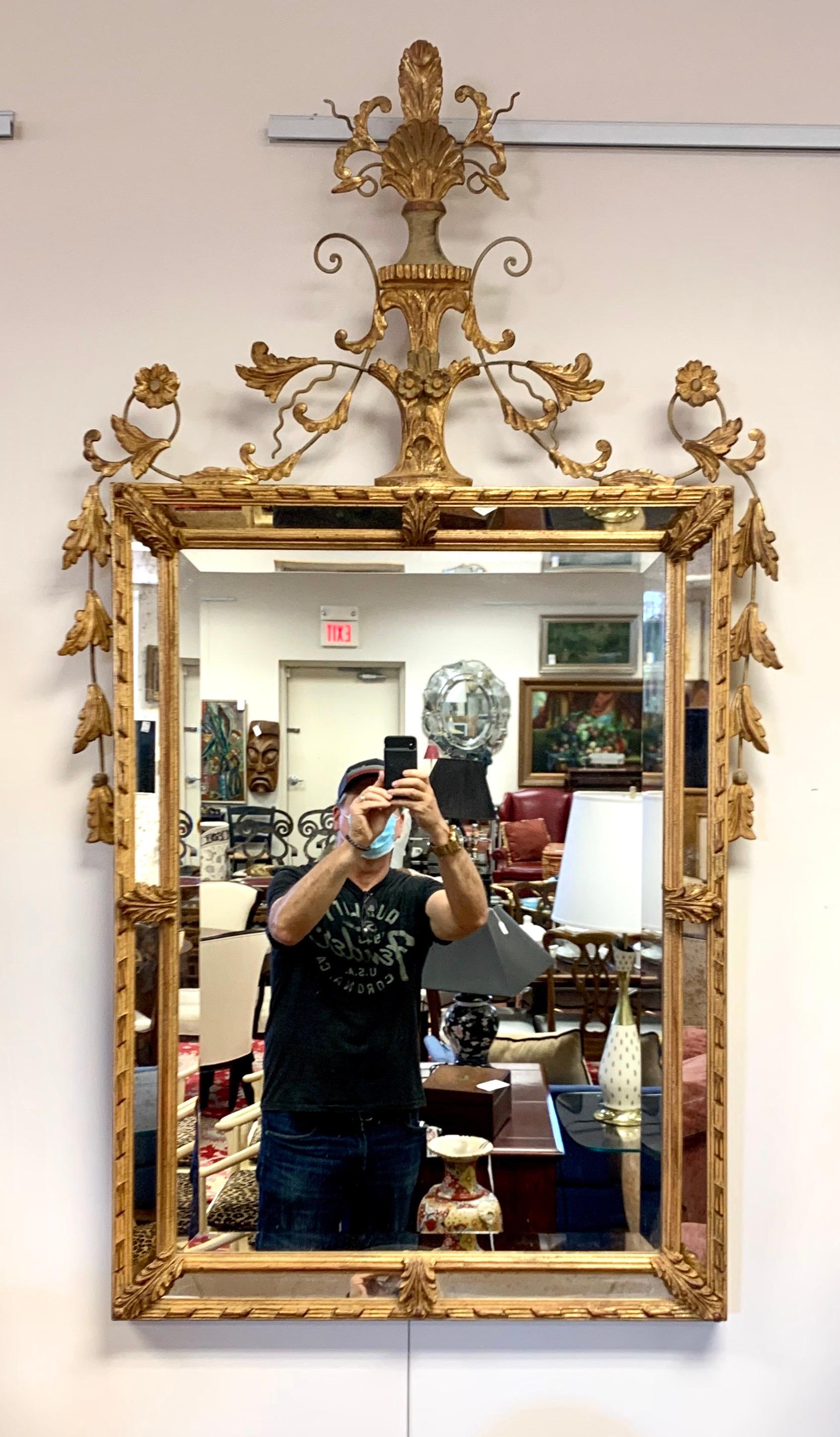 Intricately carved neoclassical giltwood wall mirror, circa early 20th century.
Decorated with a shell crest and scrolling foliate detail. Center mirror is surrounded by
a frame of beveled mirrors. Guaranteed to make a bold statement in any room.