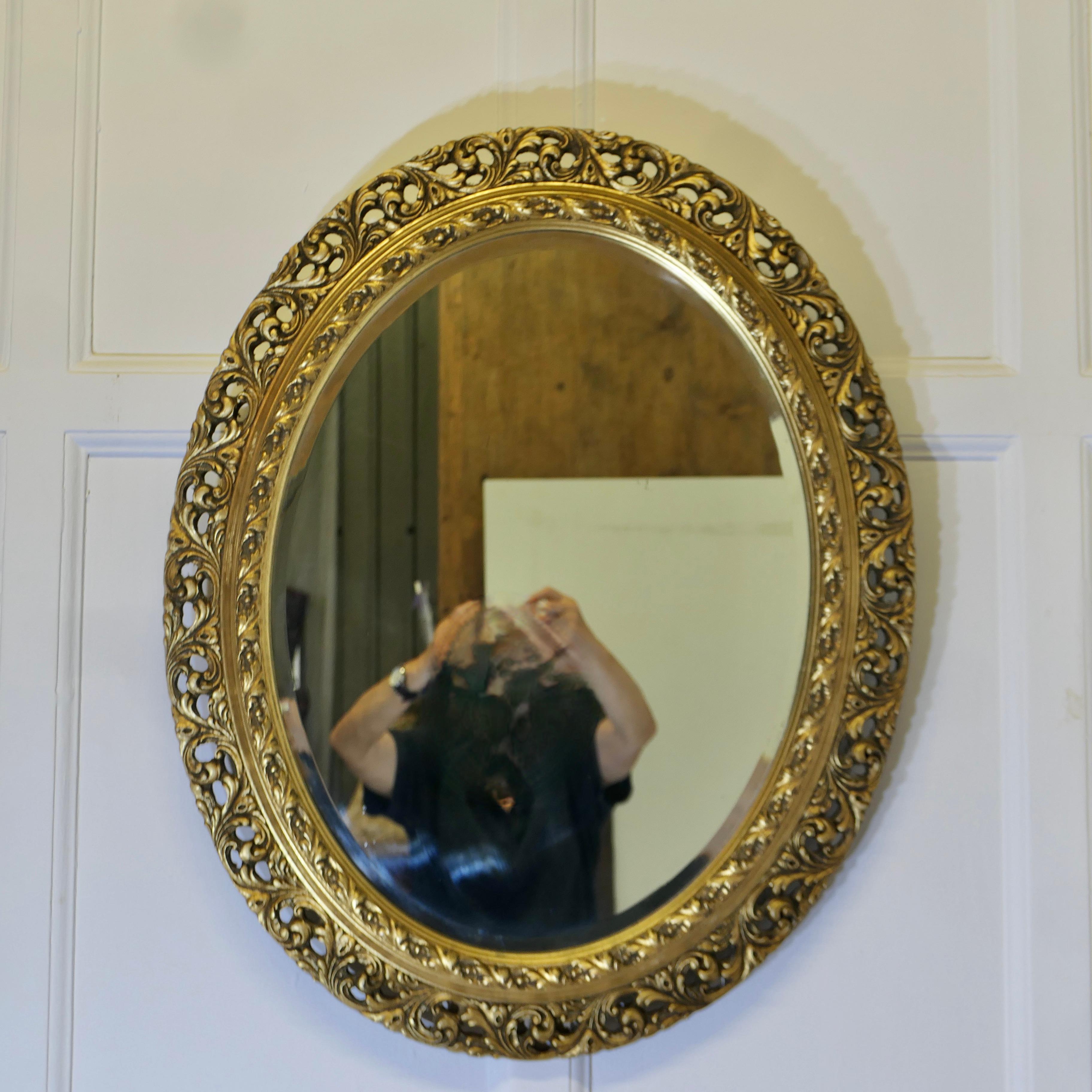 Néo-rococo Miroir mural ovale sculpté et doré    C'est un miroir très attrayant en vente