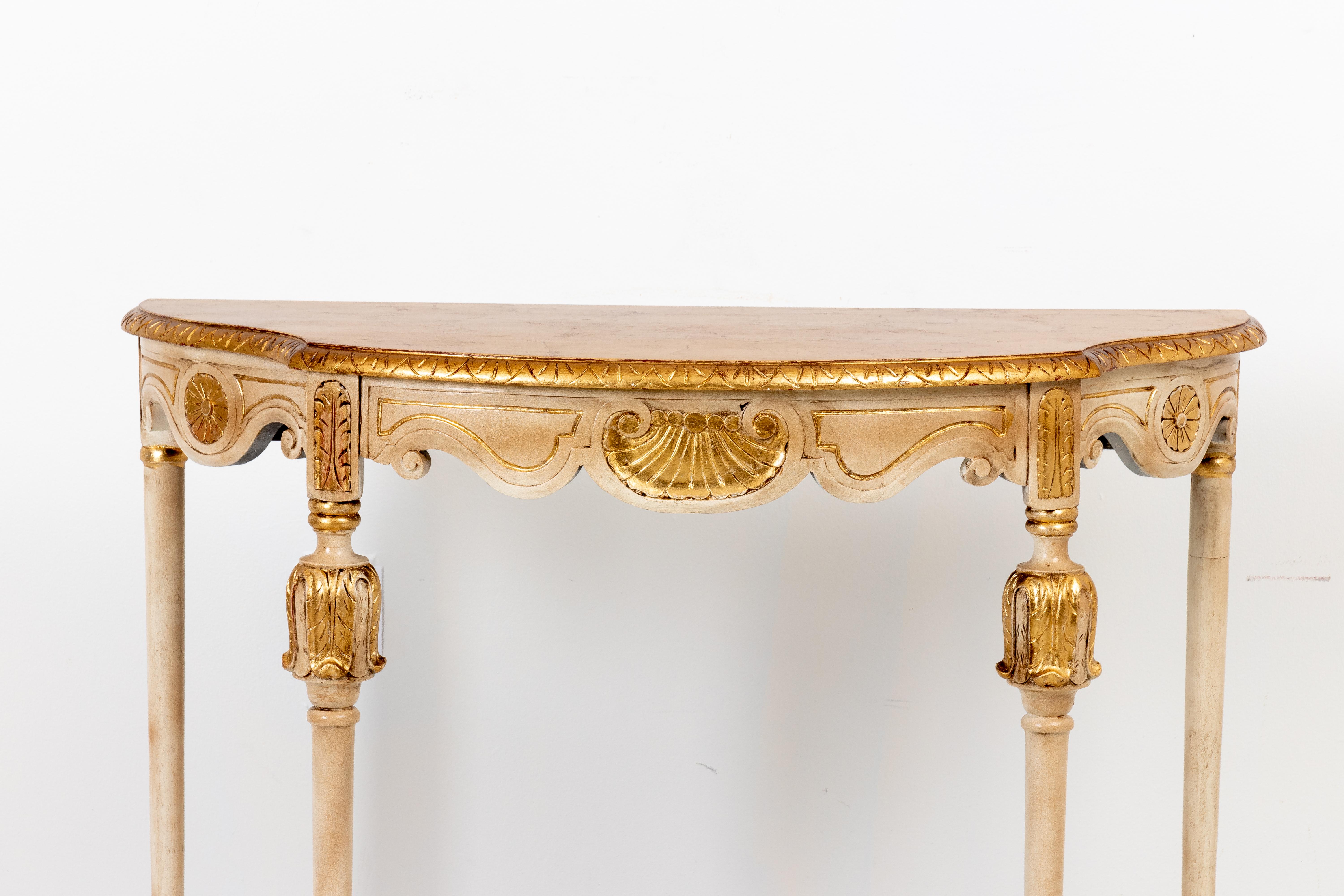 French style painted giltwood demilune console table with original patina and bottom stretcher, circa 1950s. The piece also features carved scallop shell work on the curved skirt. Please note of wear consistent with age.