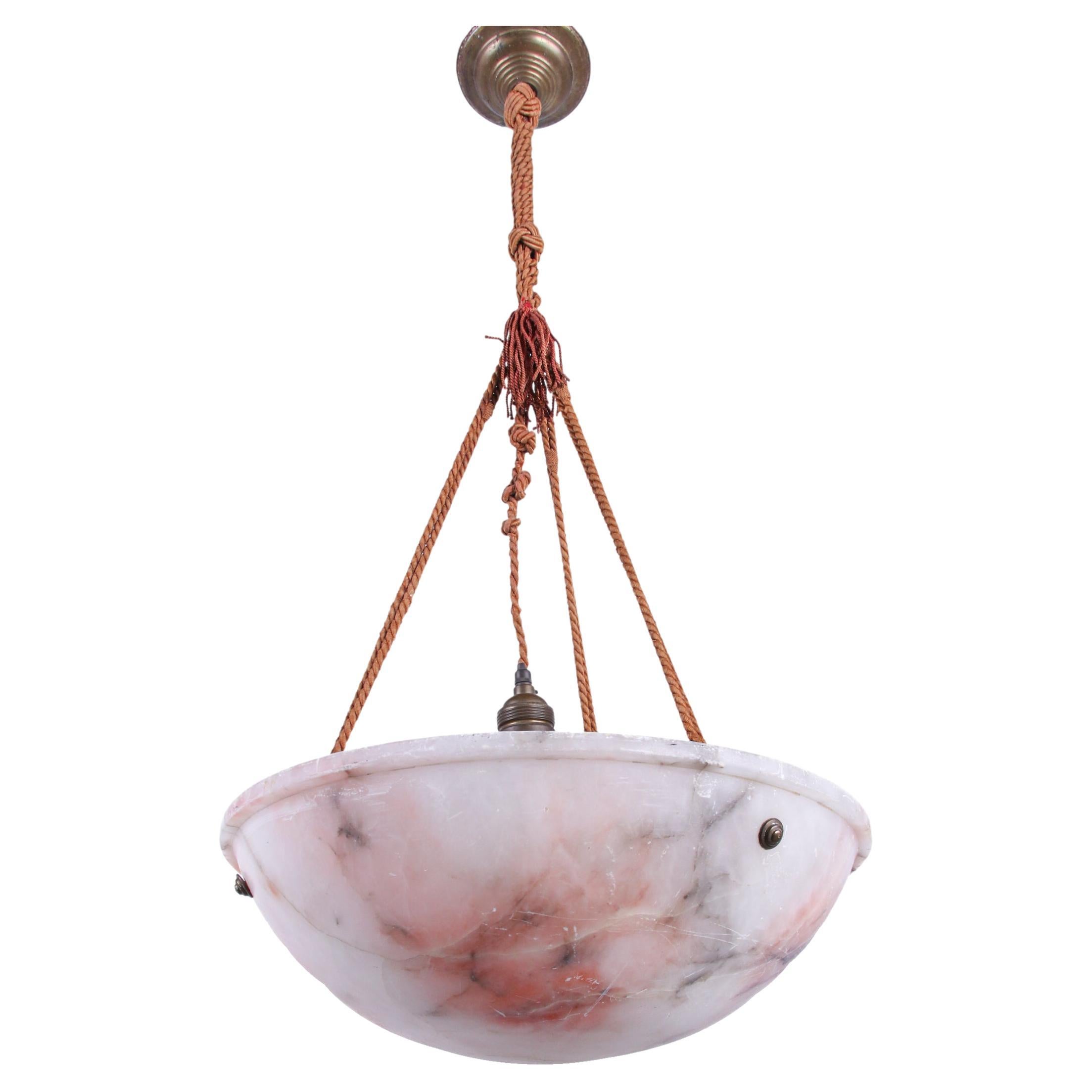 Plafonnier ancien en albâtre sculpté rose et blanc de style Art Déco avec la corde d'origine nouée à la main. La suspension diffuse une lumière ambiante fantastique. Il attire tous les regards, même lorsqu'il n'est pas éclairé. 

Matériaux :