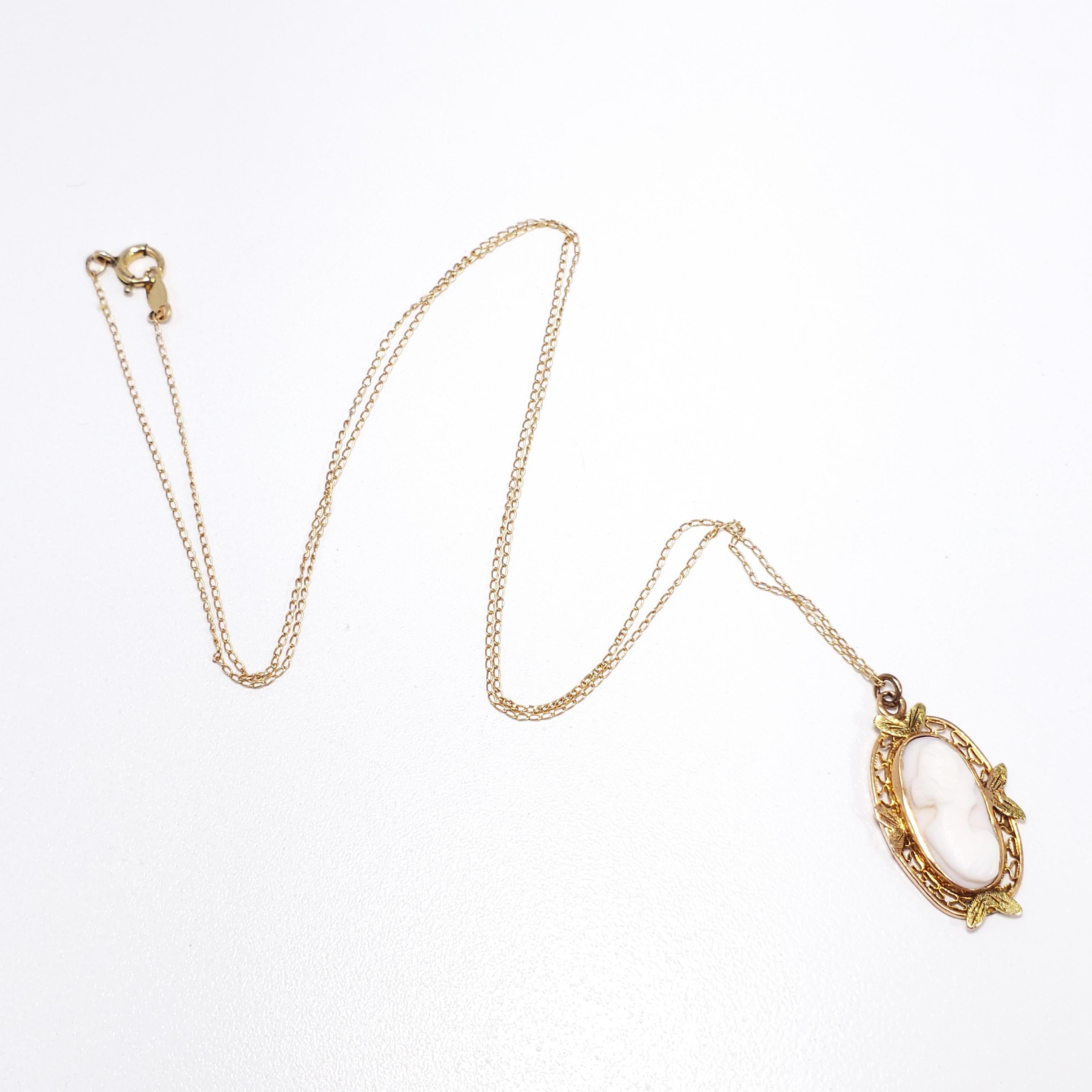 Un camée coquillage sculpté à l'arrière dans un cadre ovale filigrane, suspendu à un collier de chaîne fine complémentaire. Le pendentif est en or 10K, datant de la fin des années 1800, de style victorien. La chaîne complémentaire est en 14K, datant