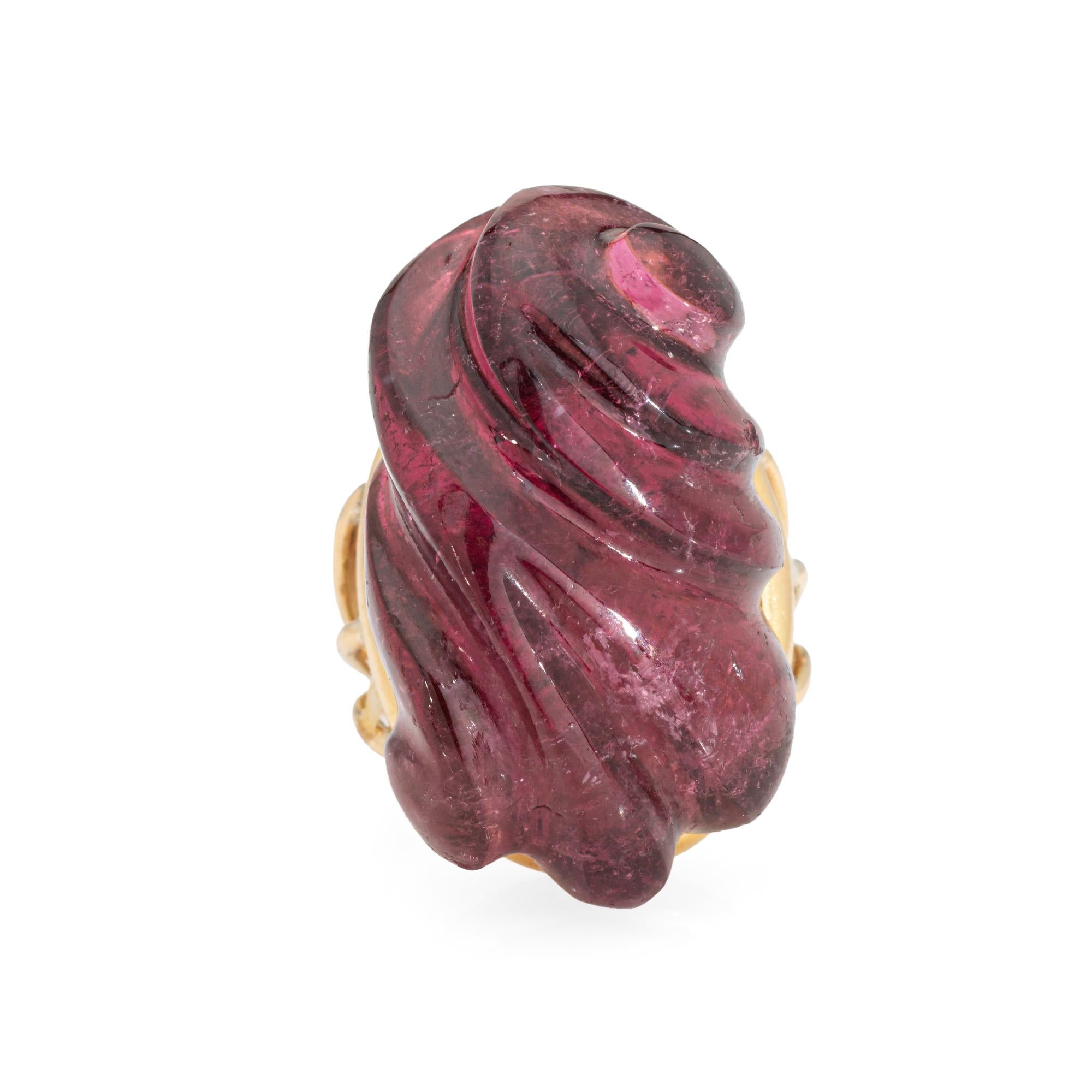 Stylish vintage carved tourmaline ring crafted in 18 karat yellow gold (circa 1960s to 1970s). 

Carved pink tourmaline measures 27.5mm x 16mm. The tourmaline is in very good condition and free of cracks or chips.  

The unique ring highlights a