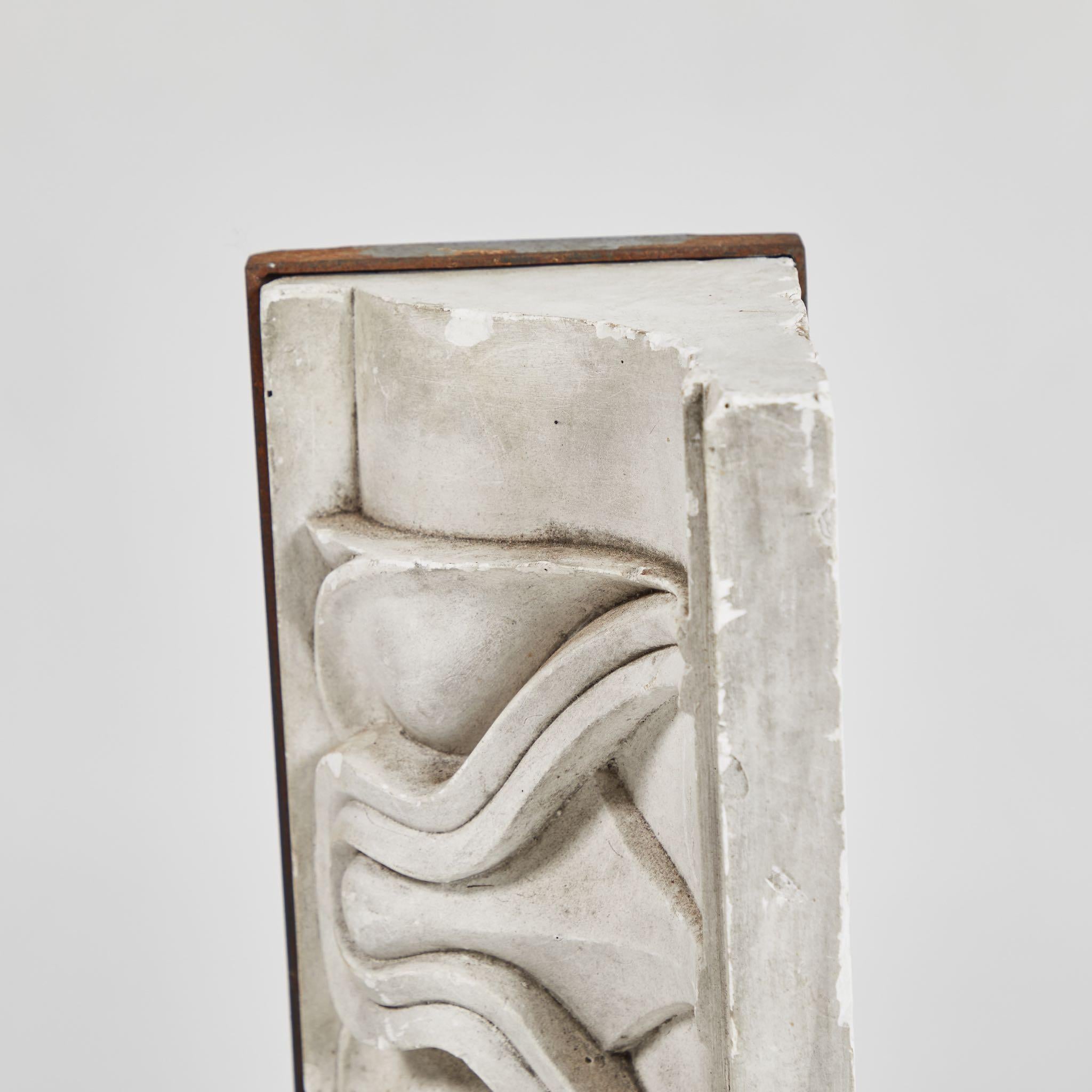 Carved plaster architectural relief mounted on an industrial iron display stand. This sort of item would have been used by an architect to model the range of flourishes available to clients. As a sculptural decorative accent, the piece adds a touch