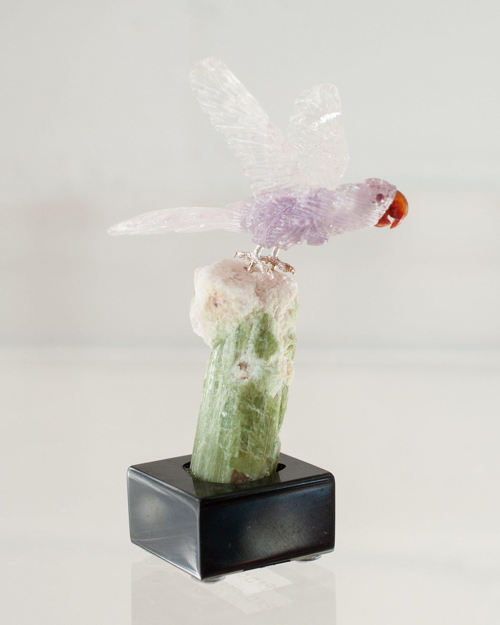 A beautiful hand carved semi precious purple amethyst Macaw mounted on a white green quartz mineral specimen base. This exotic bird is a decorative combination of ornithology and geology.