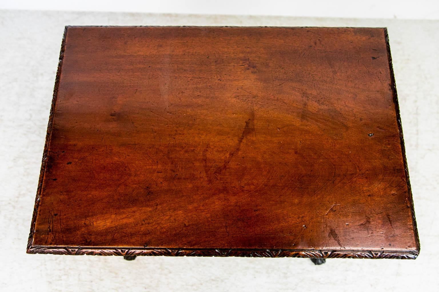 The top of this lowboy has a 19 inch single board with no splits or cracks. It has carved edge molding on all four sides. The drawer fronts are carved with floral and leaf designs on a stipled background. There is a repair at the top of the right