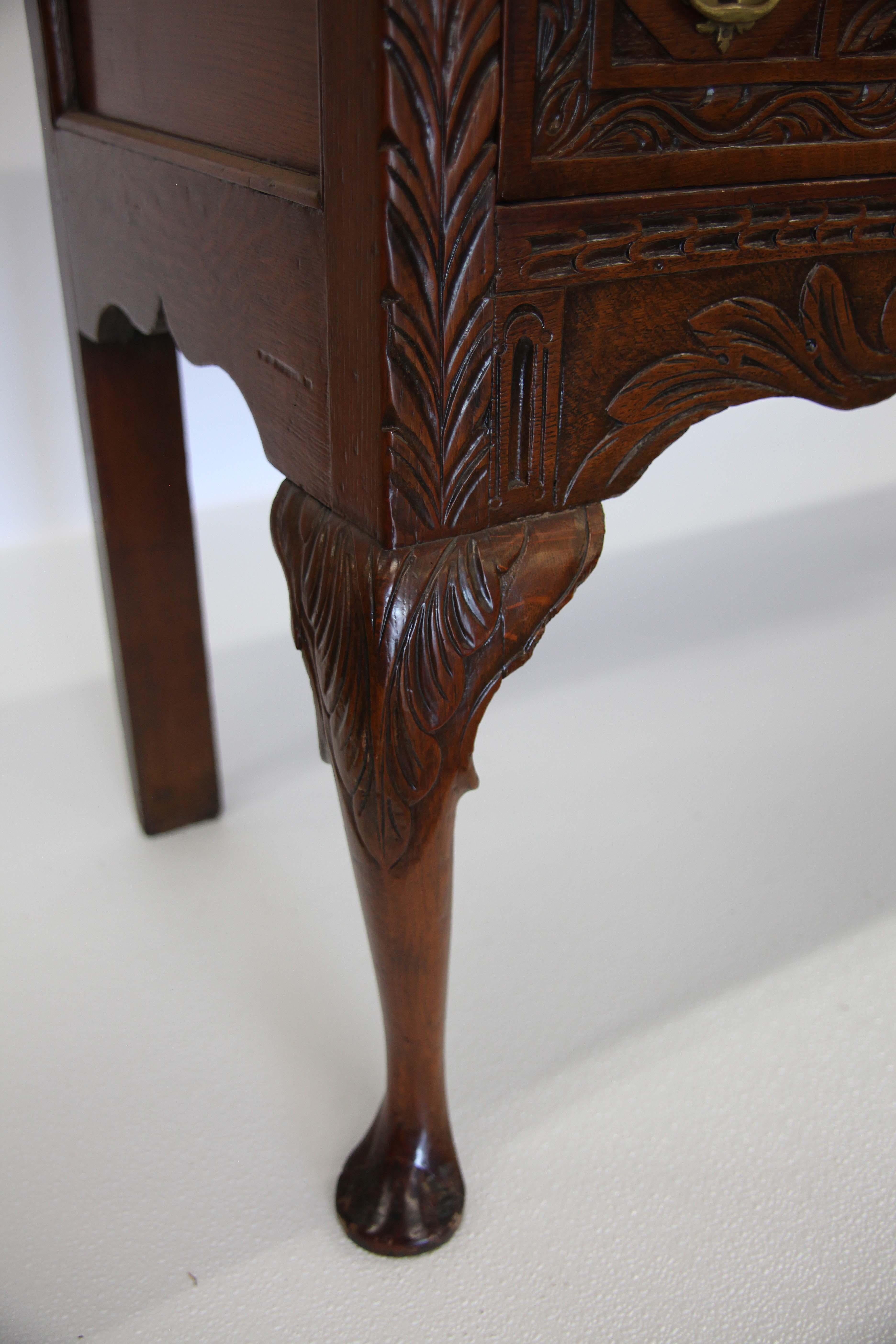 Carved Queen Anne style oak sideboard, with carved frieze above three carved drawers having open fretwork pulls, carved shaped apron, cabriole front legs with carved knee terminating with pad feet.