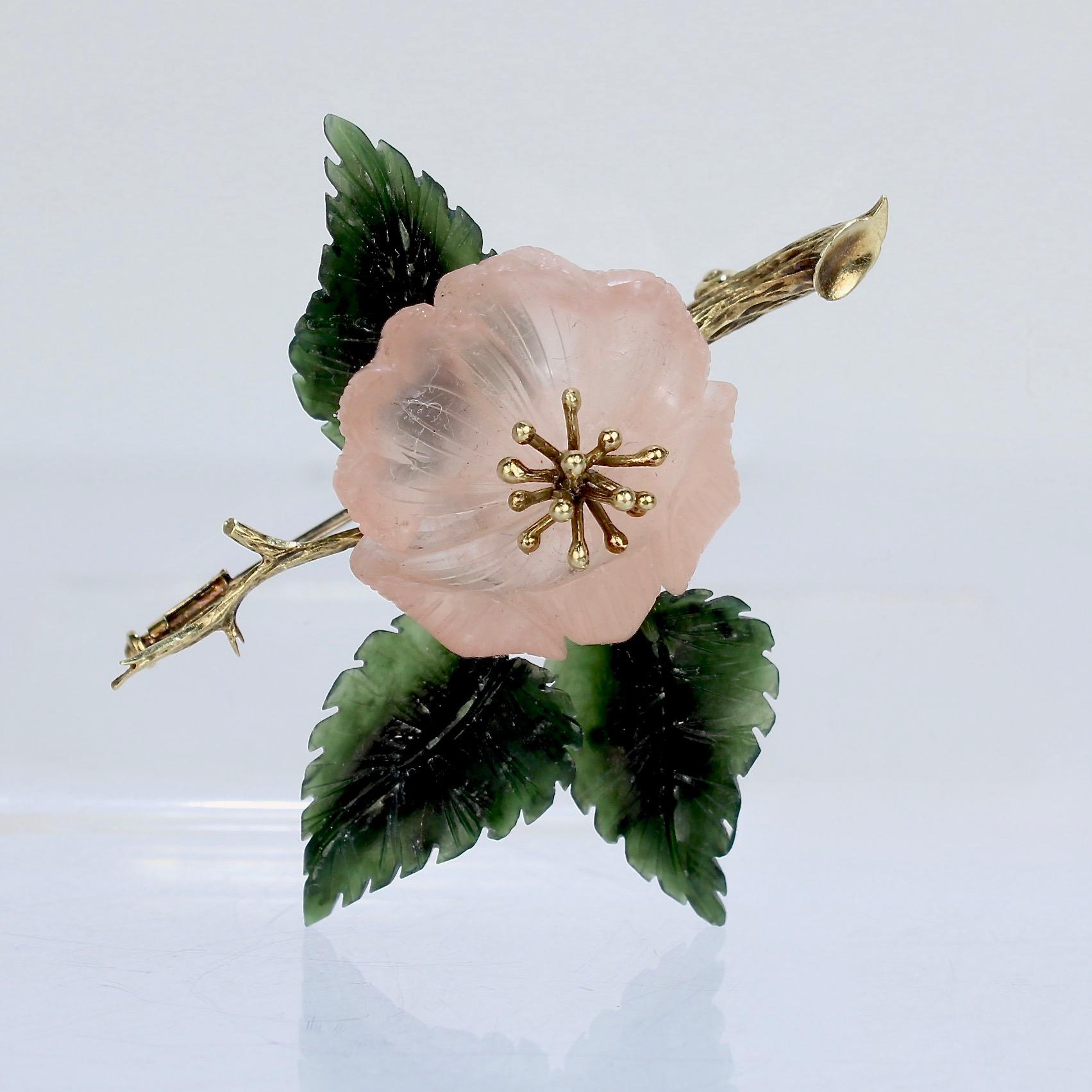 A wonderful German 14k gold and semi-precious gemstone brooch.

Fashioned as a wild rose in a creamy rose quartz and lush leaves of jade mounted on a figural twig or branch of 14k gold.

Likely carved by one of the gem-carving specialists in the