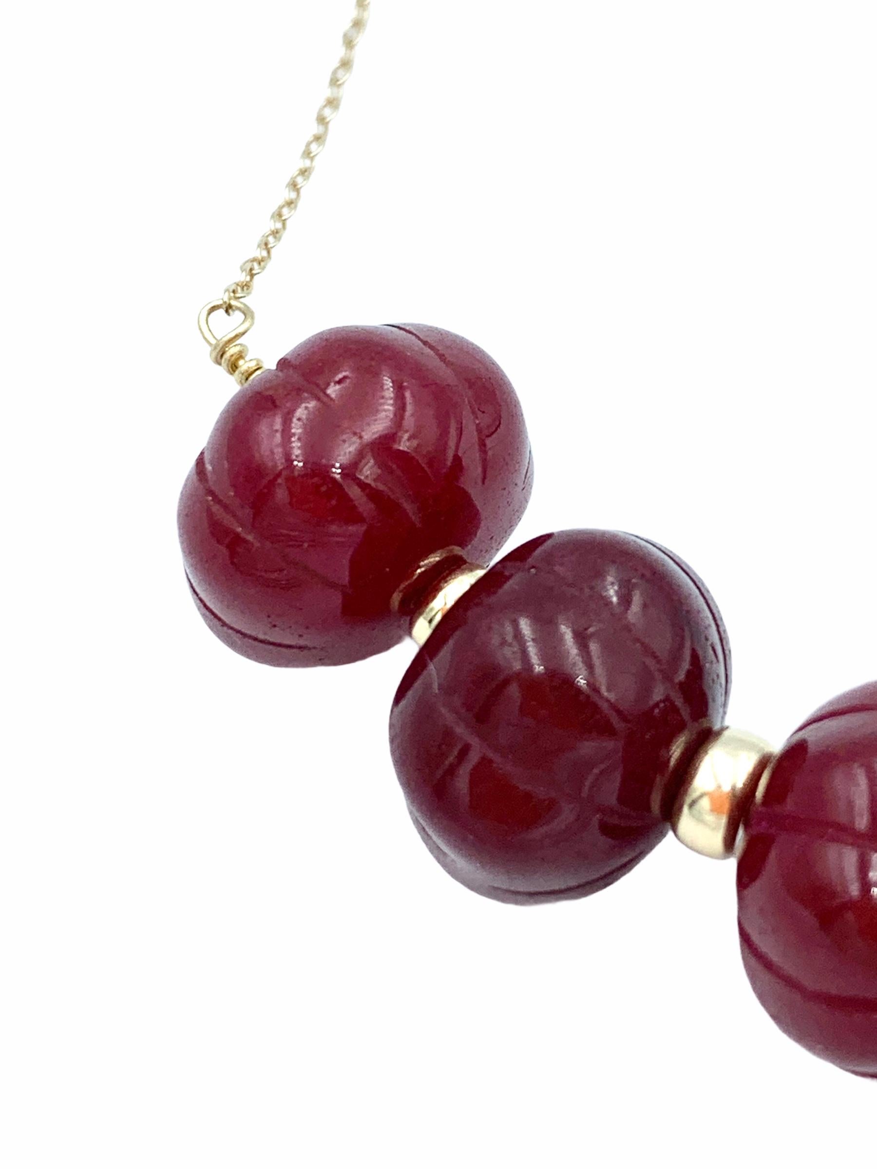 Hand made using 14 carat Yellow Gold, the suspended Carved Ruby beads are threaded together with a solid gold wire and graduated onto a delicate 1.3 mm cable chain. The intense red hues are carried throughout the misshapen beads with a  centre bead
