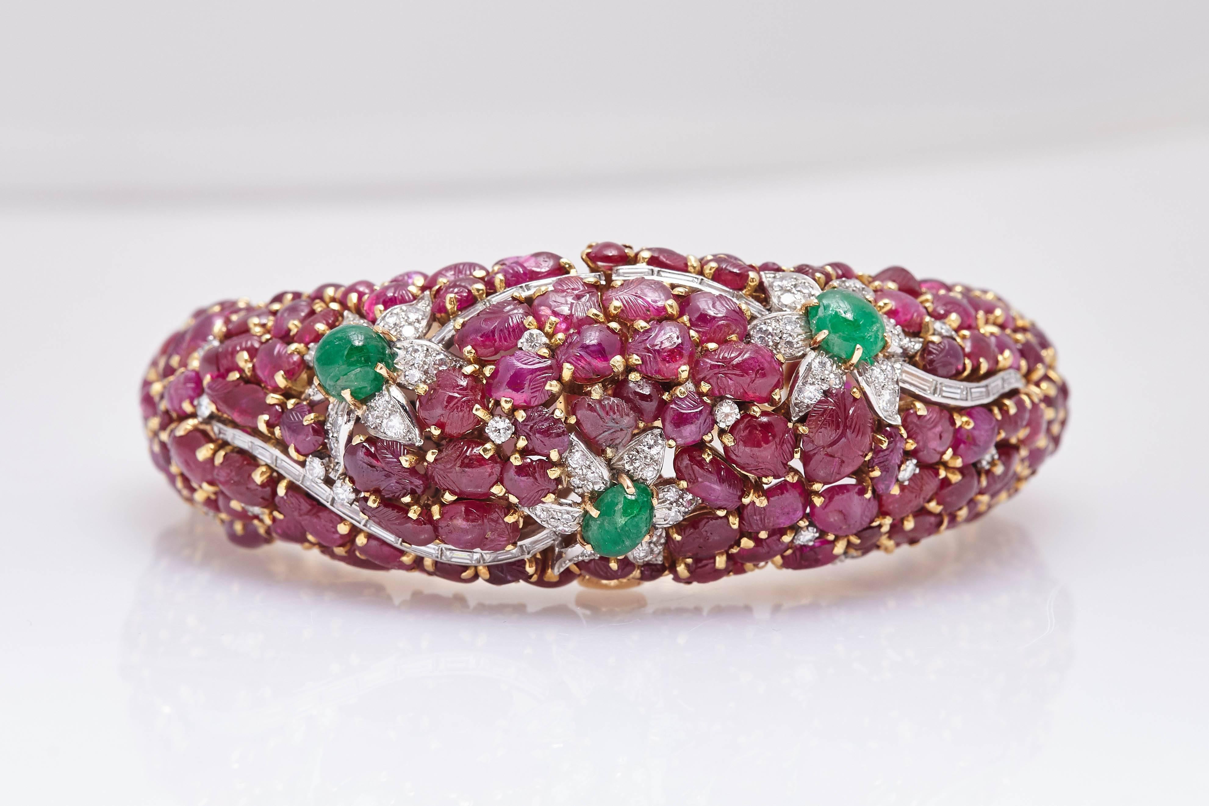 Un impressionnant bracelet avec rubis, émeraudes et diamants sculptés, monté sur or jaune 18 carats. Vers les années 60.
