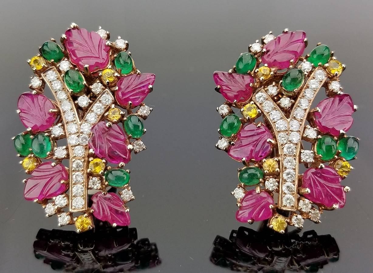 A unique, art-deco looking bracelet and earring duo, consisting a mix of carved Burmese Rubies,  Zambian Emeralds and Sri Lankan Yellow Sapphires, all set in 18K Gold.

Bracelet:
Diamond 4.47 carat / Ruby 47.8 carat / Yellow Sapphire 6.4 carat /