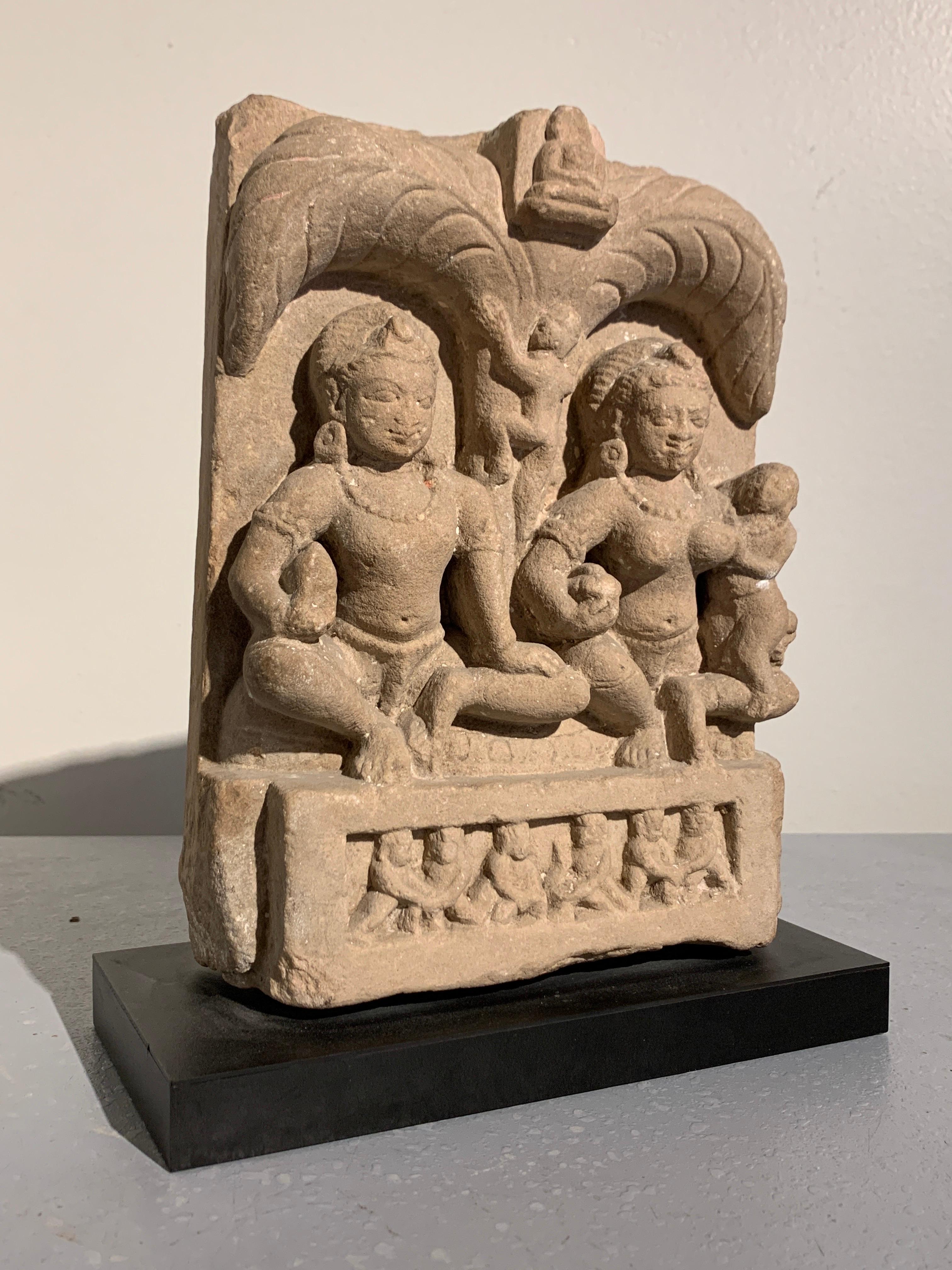 A fine and rare Indian carved sandstone stele of a Jain family group, Sarnath style, early Indian Medieval period, 6th-7th century, Uttar Pradesh, India.

Carved from a single block of buff sandstone, the stele features a Jain family group comprised