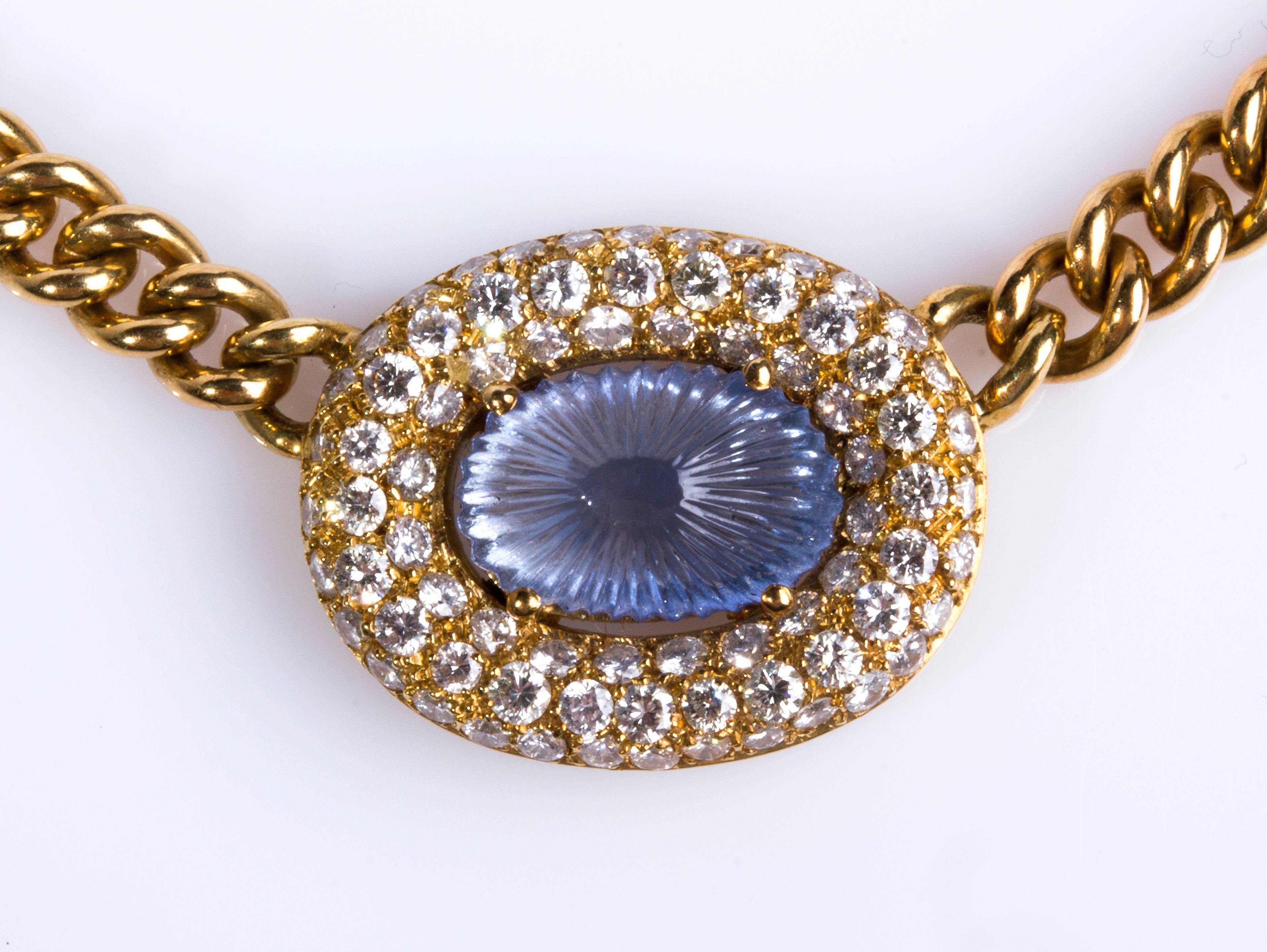 Realized in yellow gold, carved sapphire pendant surrounded by old cut diamond weighing 2.60 ct.