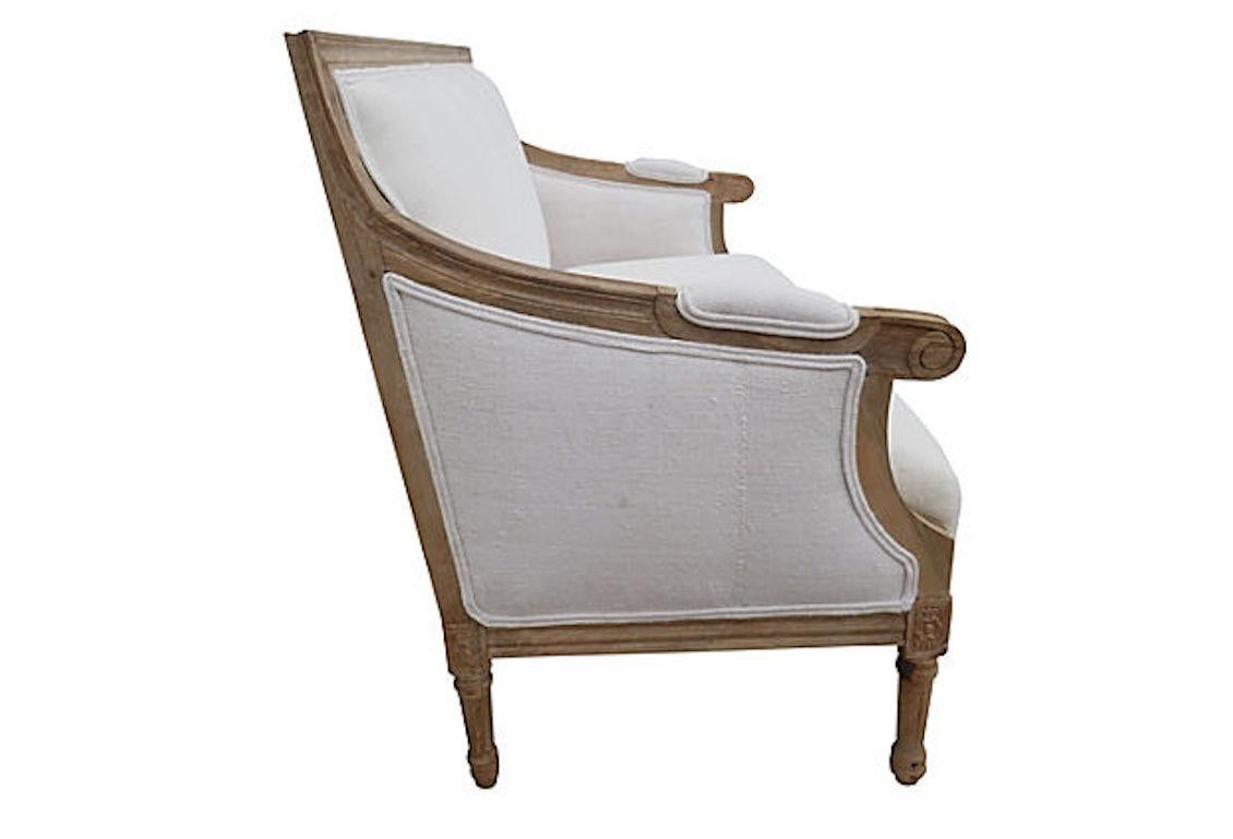 Carved Hardwood settee in French Vintage Hand-Spun Natural Linen. Natural tone raw wood frame and textural linen featuring desirable original hand whipstitch accenting and ultra-soft hand textural weave. Relaxed linen seat.