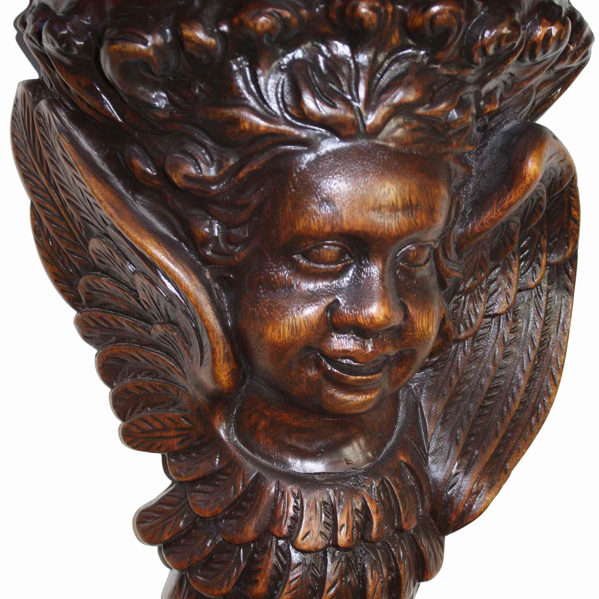 The innocent faces of two cherubs are intricately carved on the supports for this beautiful shelf. Each smiling face is framed by angelic wings.

 