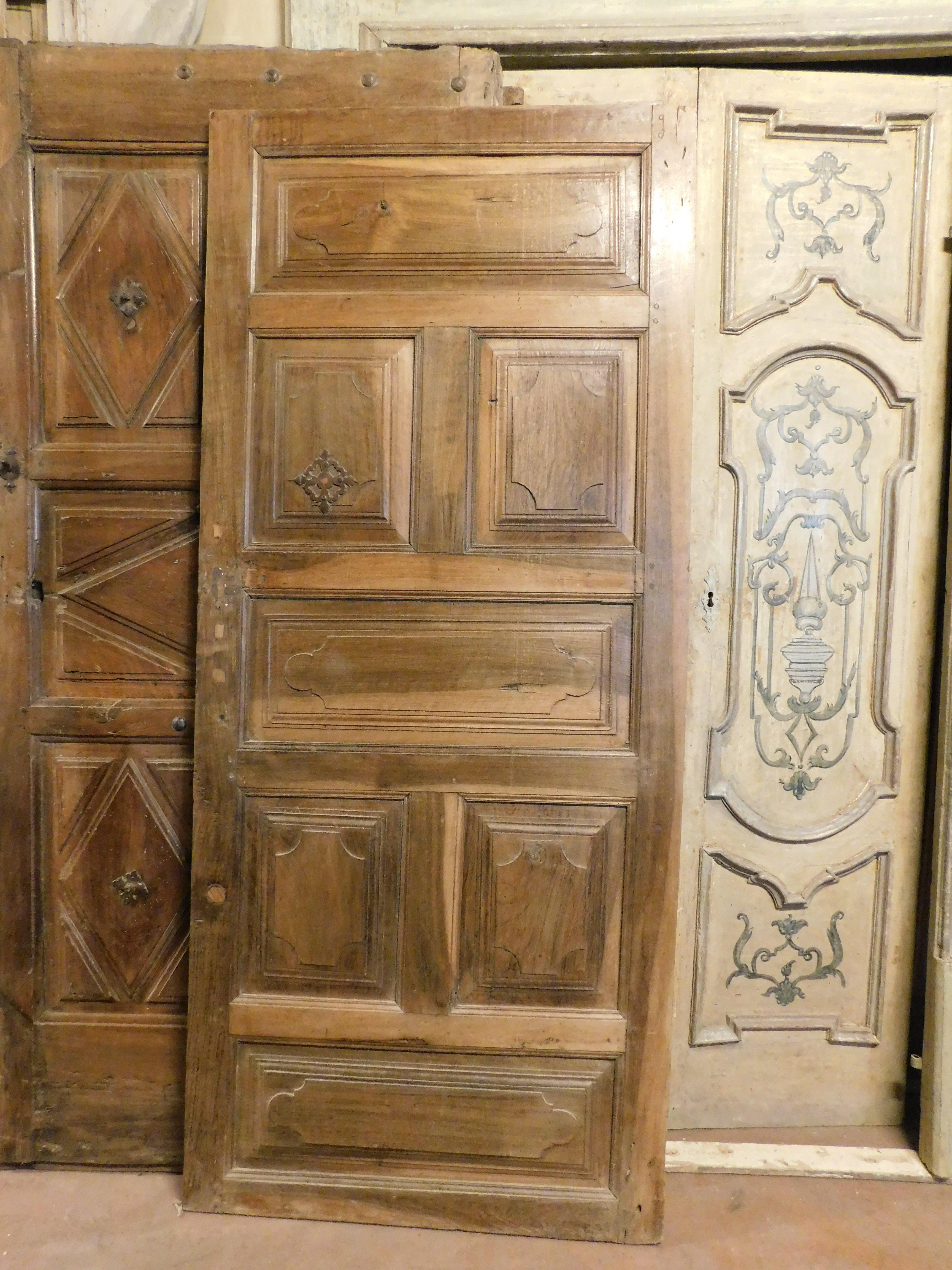 Antike einflügelige Innentür aus wertvollem massivem Nussbaumholz, reich handgeschnitzt mit 7 originalen Paneelen und Beschlägen, glatte Rückseite, handgefertigt von einem norditalienischen Kunsthandwerker aus dem 18. Jahrhundert, Maße B 87 cm x H